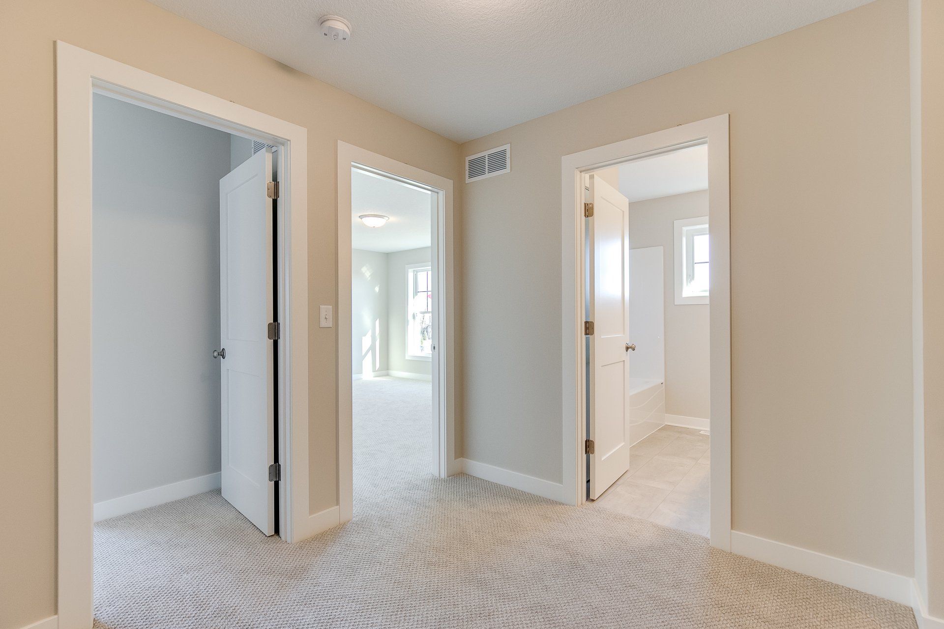 A hallway with two doors leading to different rooms in a house.