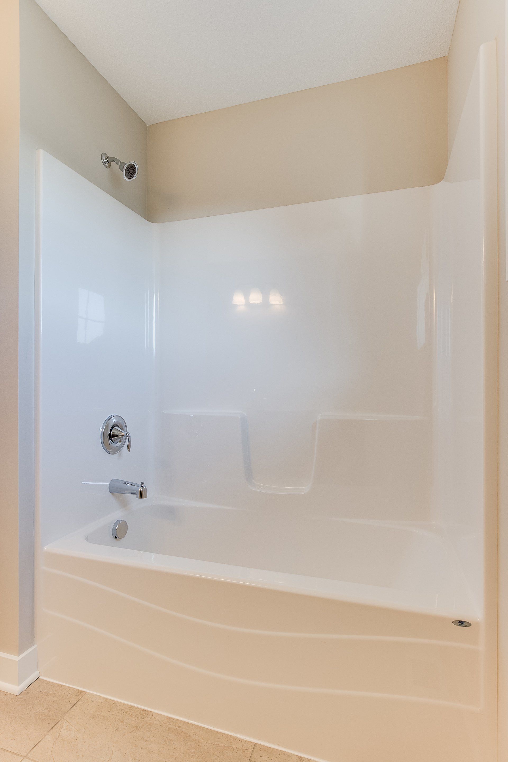 There is a bathtub in the bathroom with a shower stall.