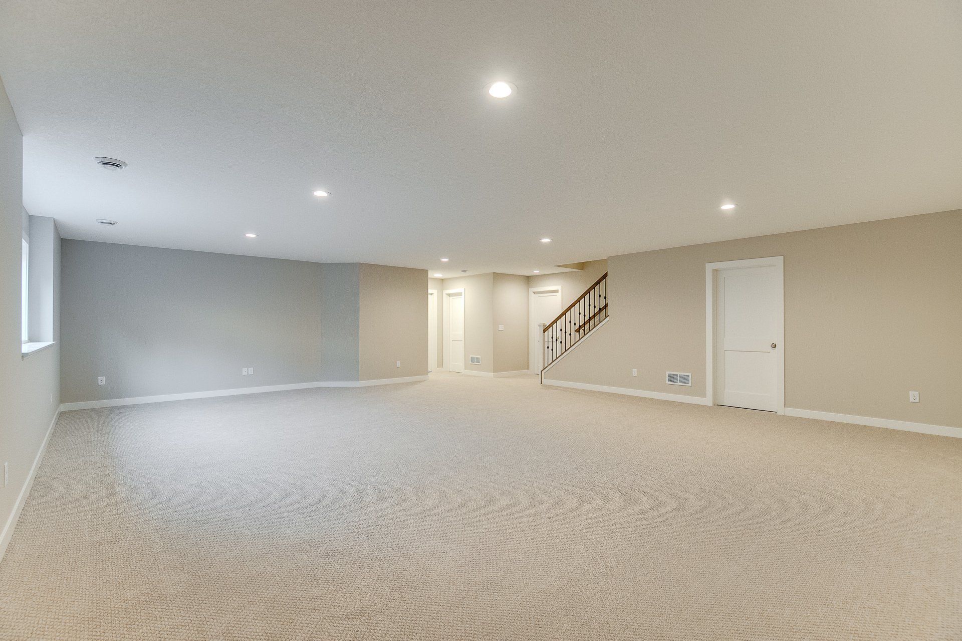 An empty basement with a staircase leading up to the second floor.
