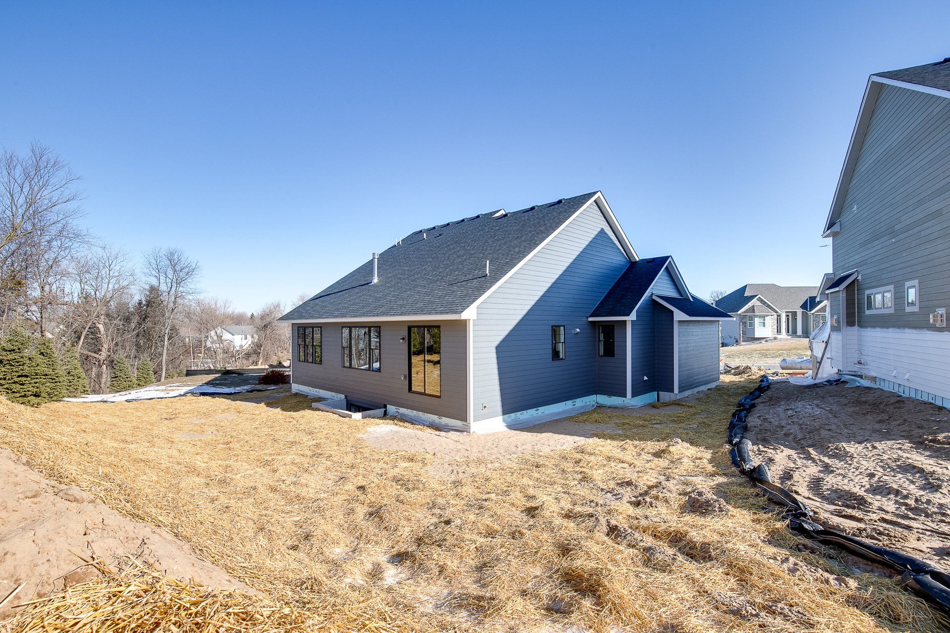 A large house with a lot of windows is sitting on top of a hill.