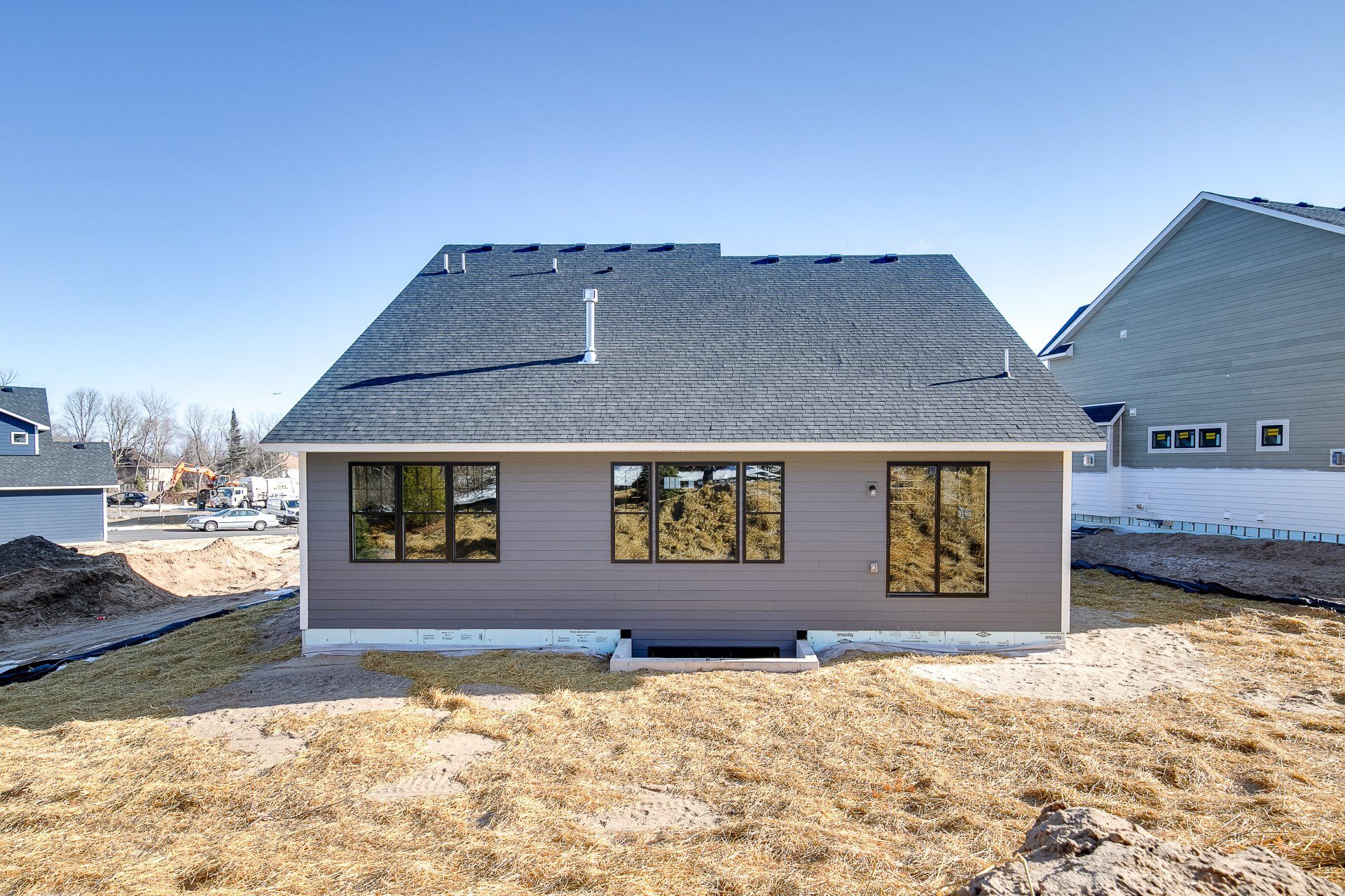 The back of a house with a lot of windows and a roof.
