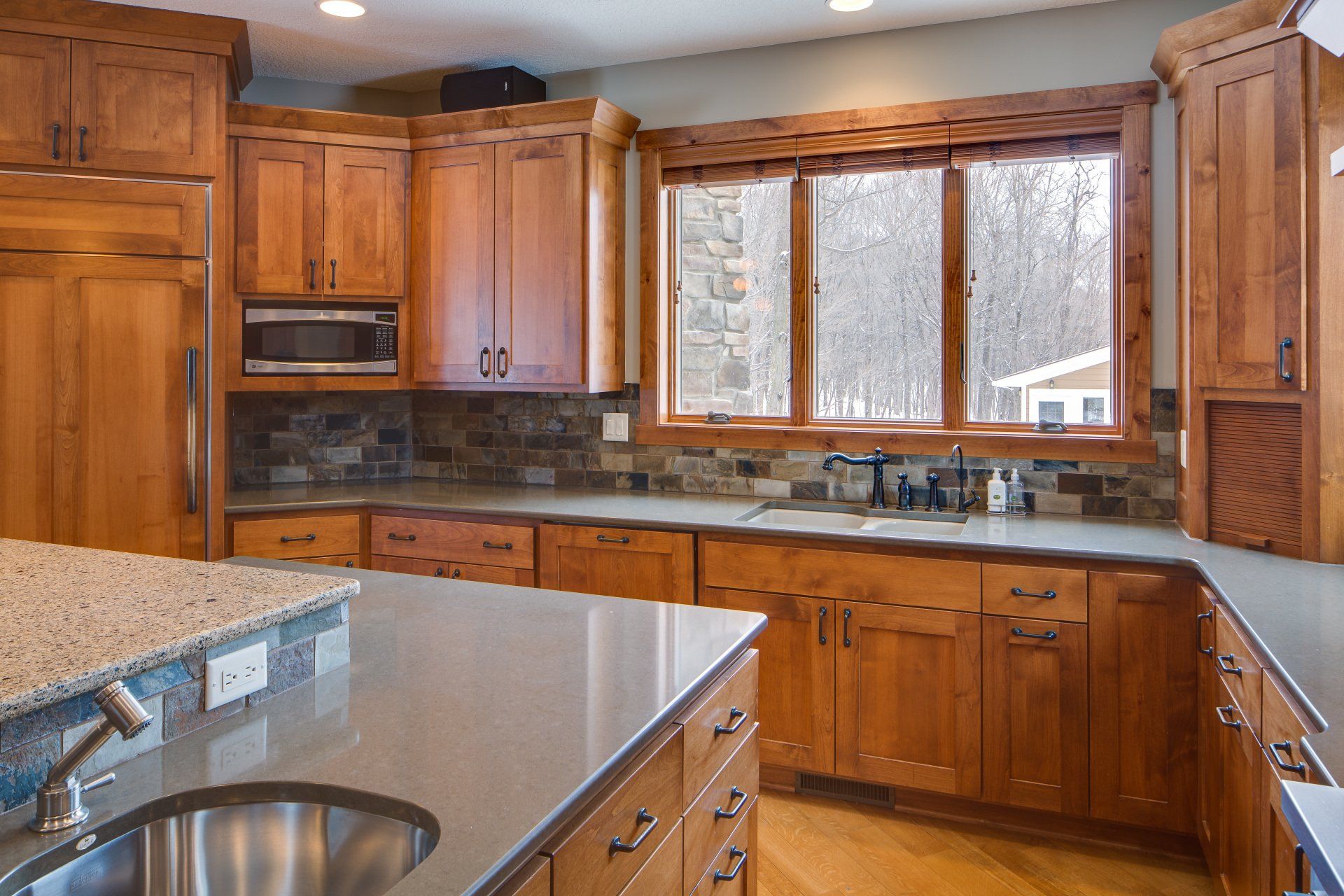 A kitchen with wooden cabinets and a stainless steel sink