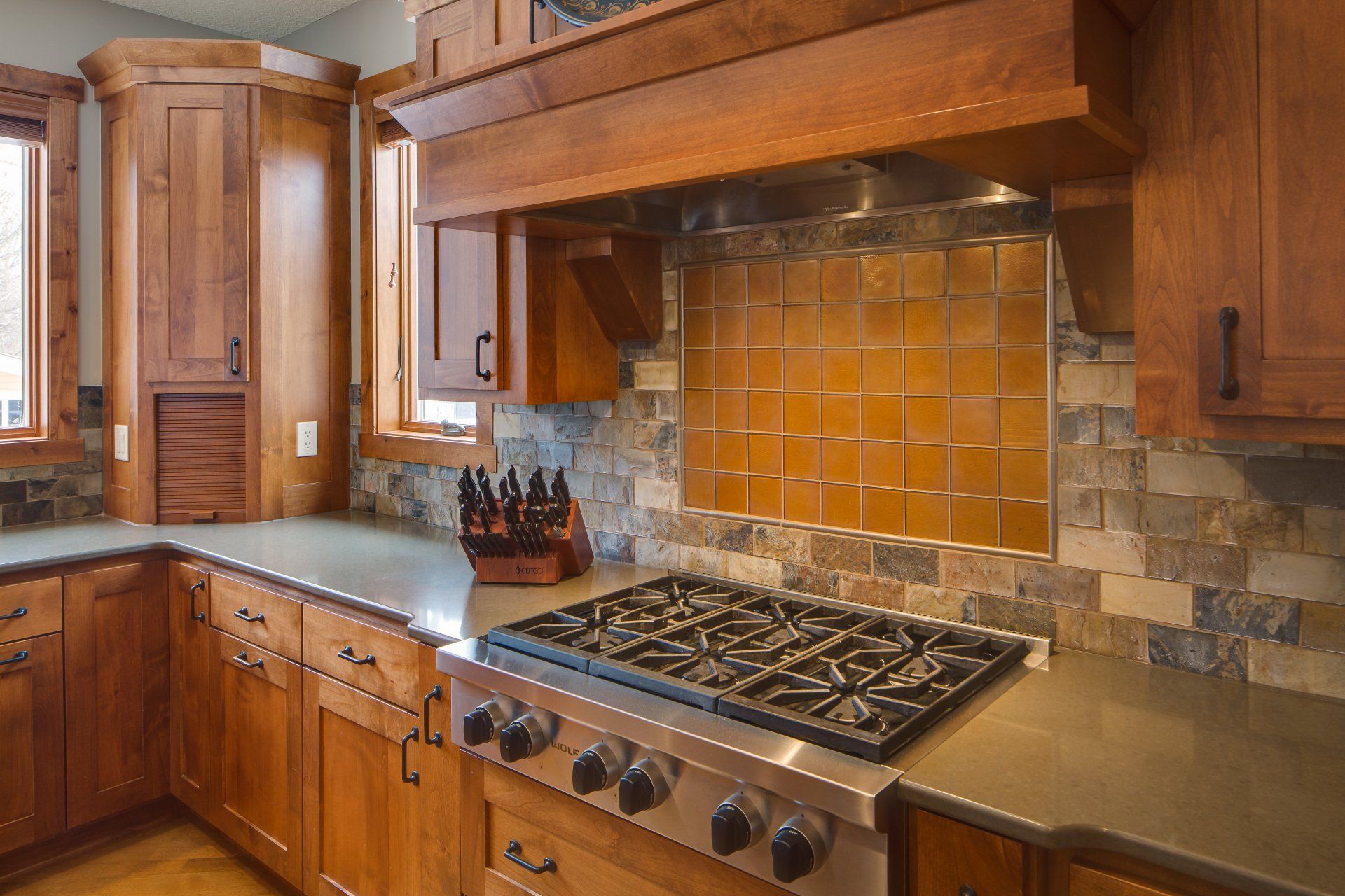 A kitchen with wooden cabinets and a stove top oven.