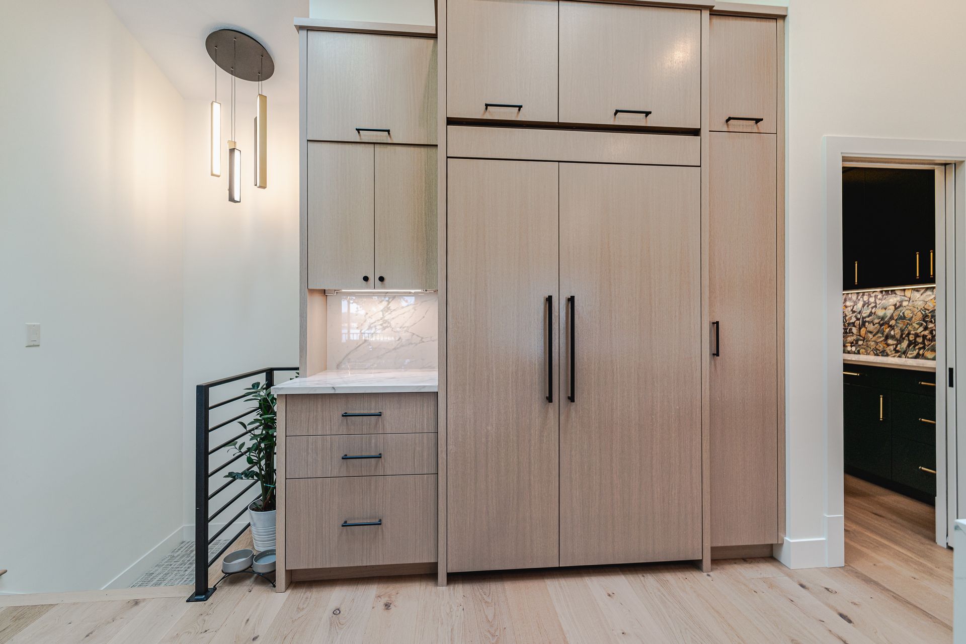 A kitchen with wooden cabinets and a refrigerator built into the wall.