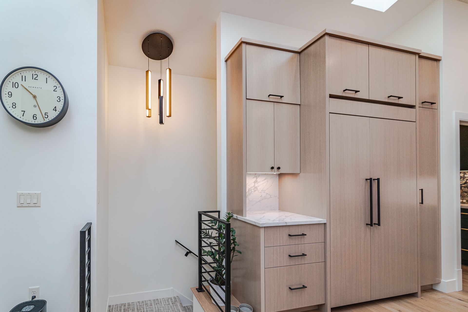 A kitchen with wooden cabinets and a clock on the wall.