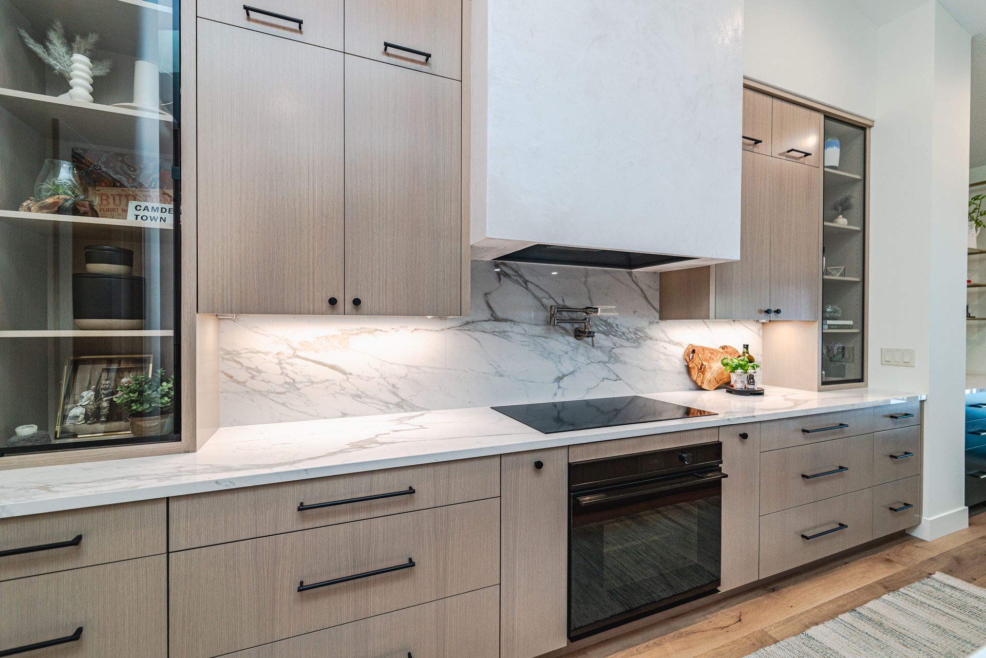 A kitchen with wooden cabinets, marble countertops, and a stove.
