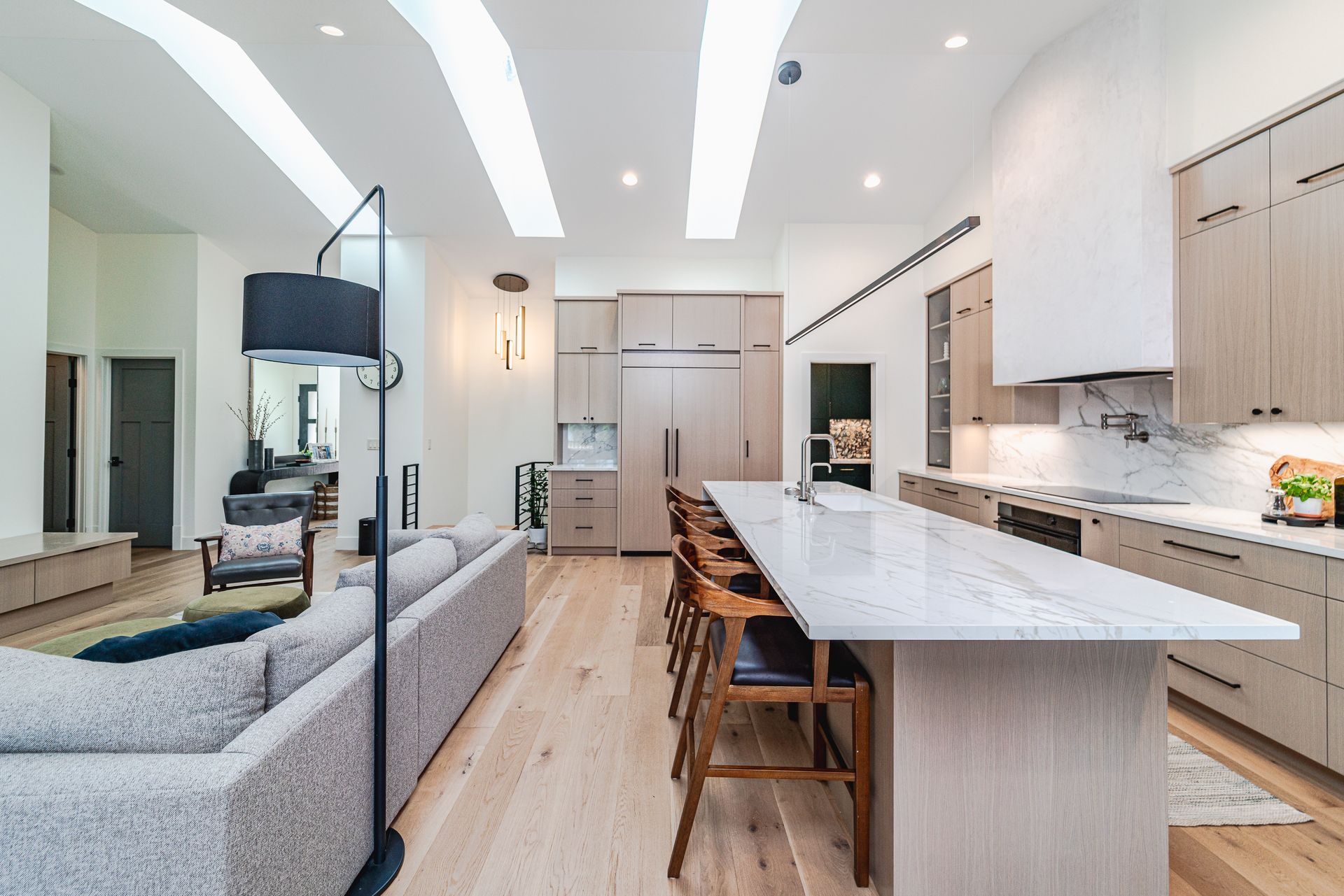A kitchen with a large island and a couch in the background.