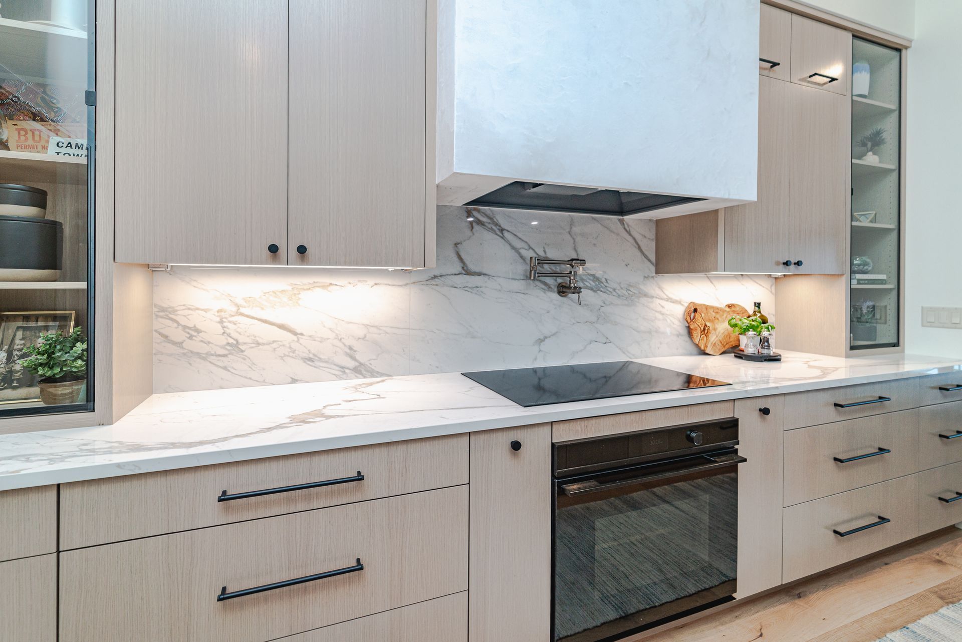 A kitchen with white cabinets, stainless steel appliances, and marble countertops.