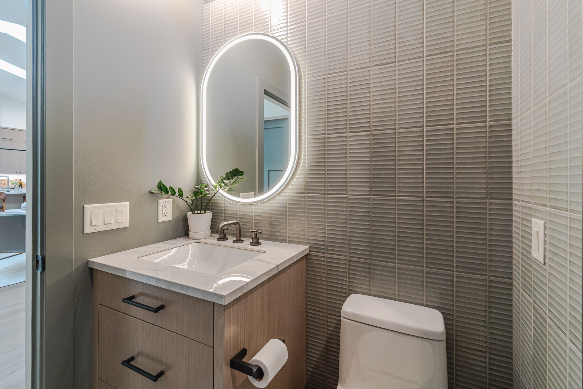 A bathroom with a sink, toilet, and mirror.