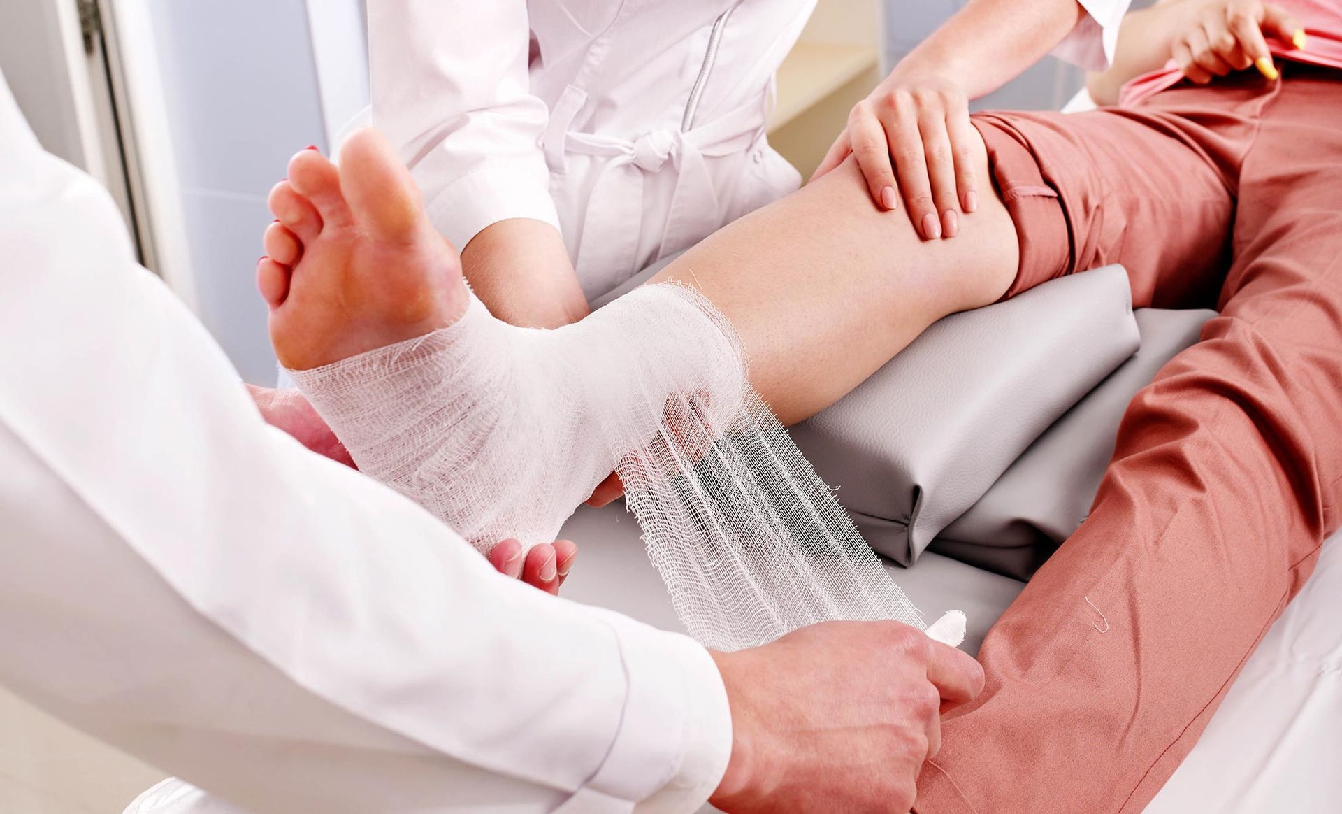 a doctor is wrapping a patient 's leg with a bandage