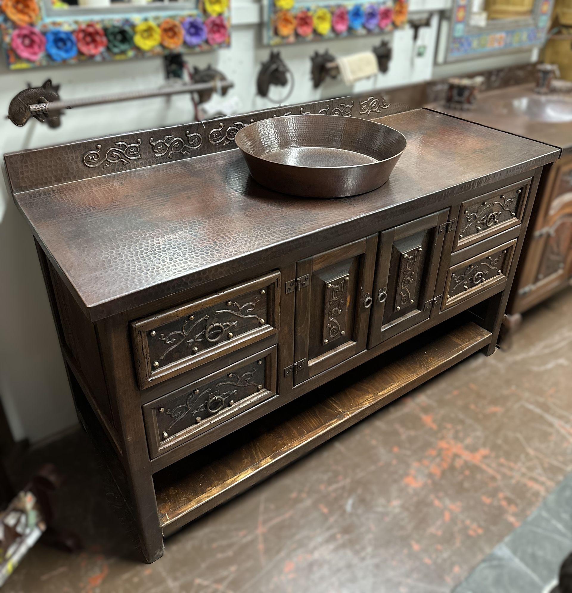 Copper vanity with a matching sink. The vanity has ornate carvings on the drawers and doors.