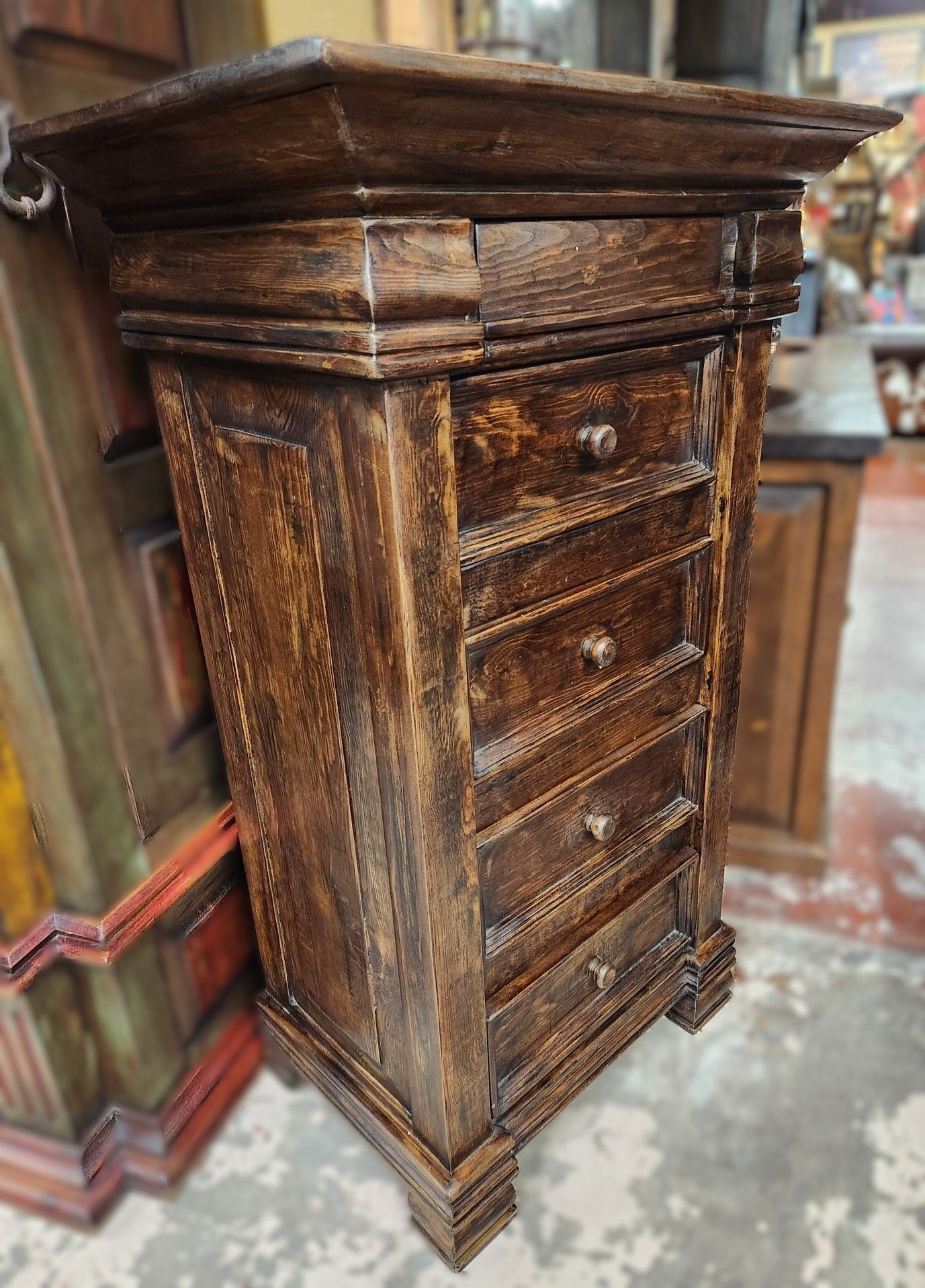 Wooden nightstand with five drawers, brown with distressed finish.