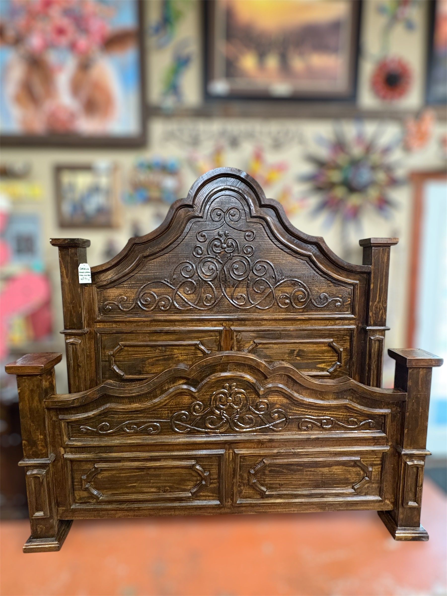 Dark wooden bed frame with ornate carvings. The headboard and footboard are elaborately detailed.