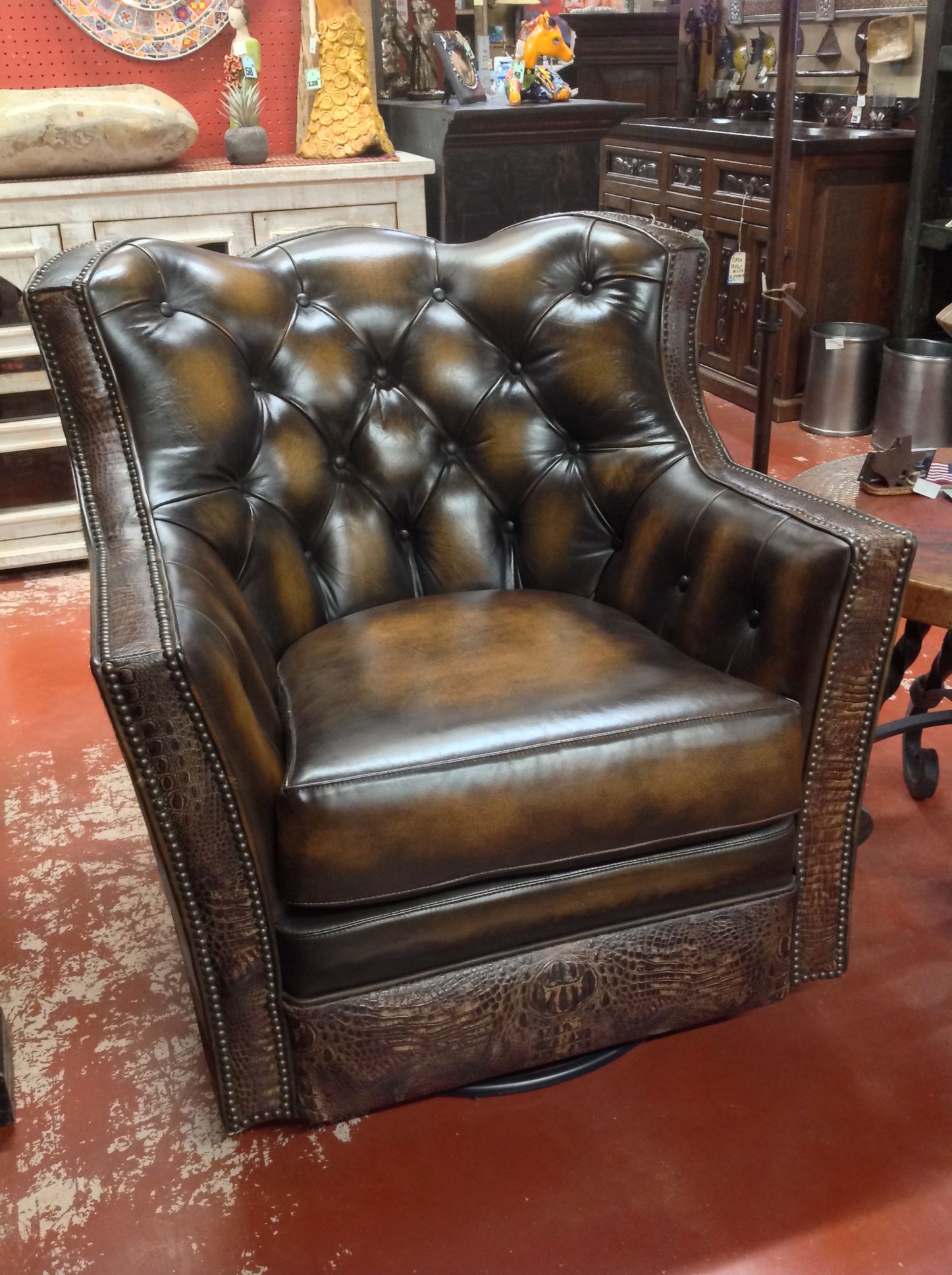 Brown leather tufted swivel armchair in a furniture store.