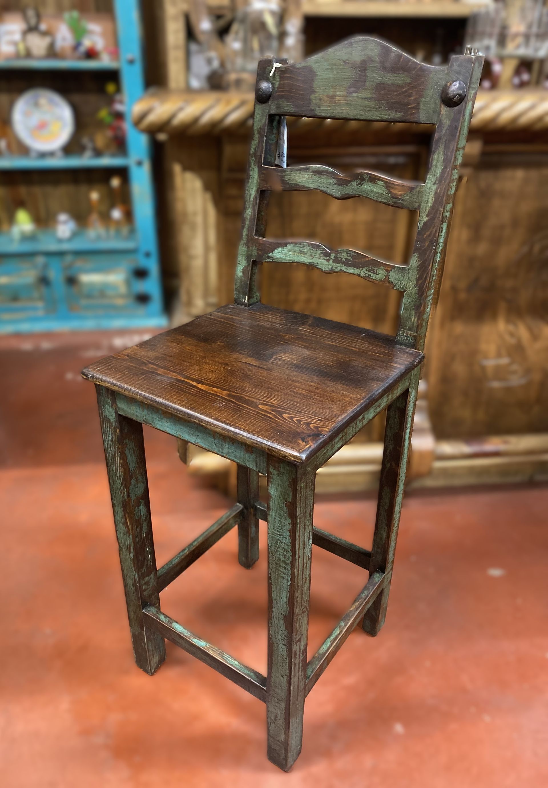 Rustic wooden bar stool with a turquoise finish and a brown seat.