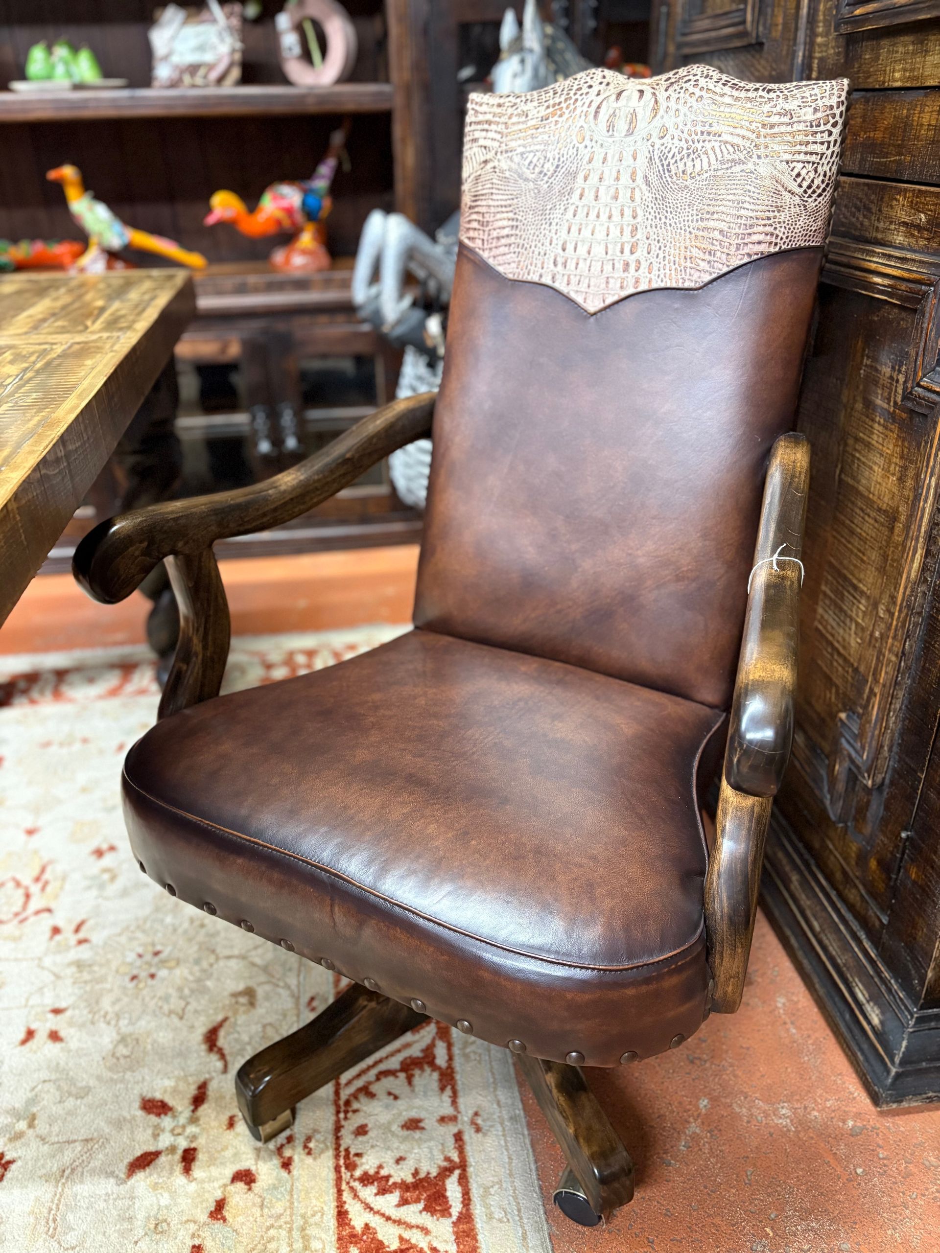 Brown leather office chair with wood accents, including a textured backrest, against a rustic interior.
