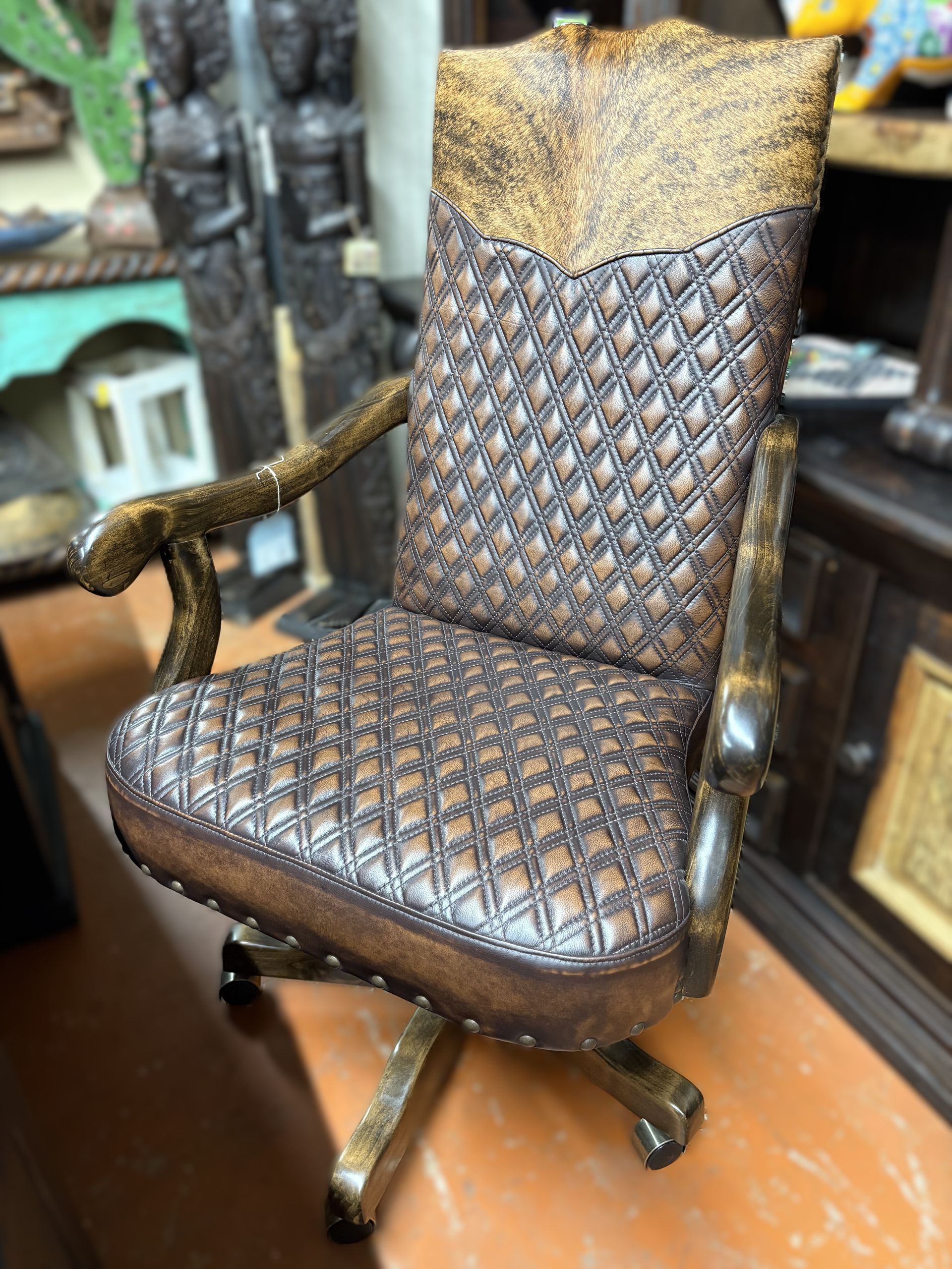 A brown and tan leather office chair with a diamond-stitched seat and back, featuring faux animal-hide accents and wooden armrests.
