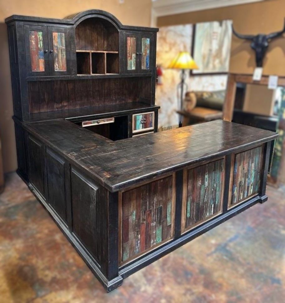 Dark stained, L-shaped rustic wooden desk with colorful accent panels, topped by a matching hutch with shelves.