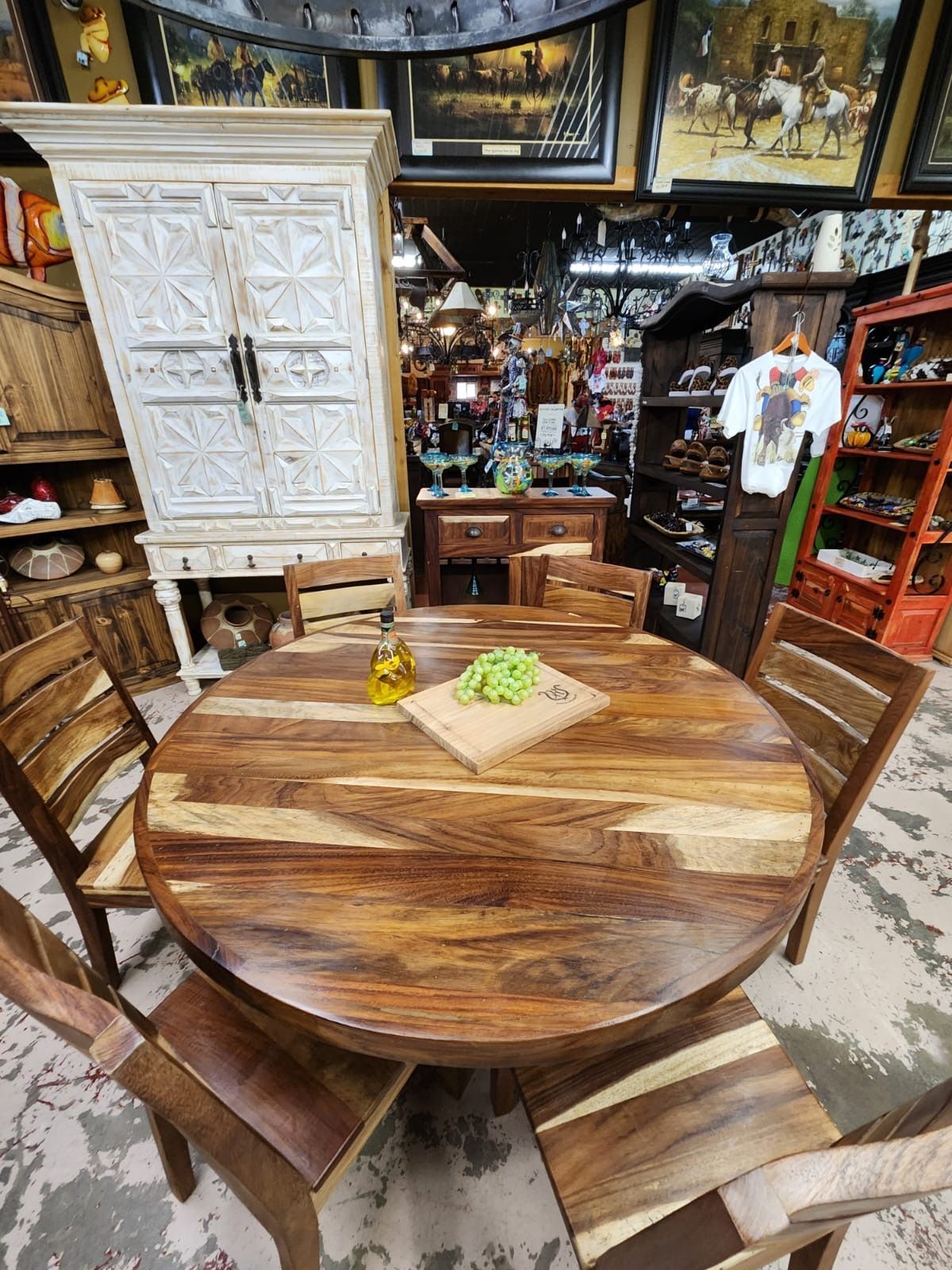 A rustic wooden dining table with six chairs in a furniture store, surrounded by other furniture and decor.