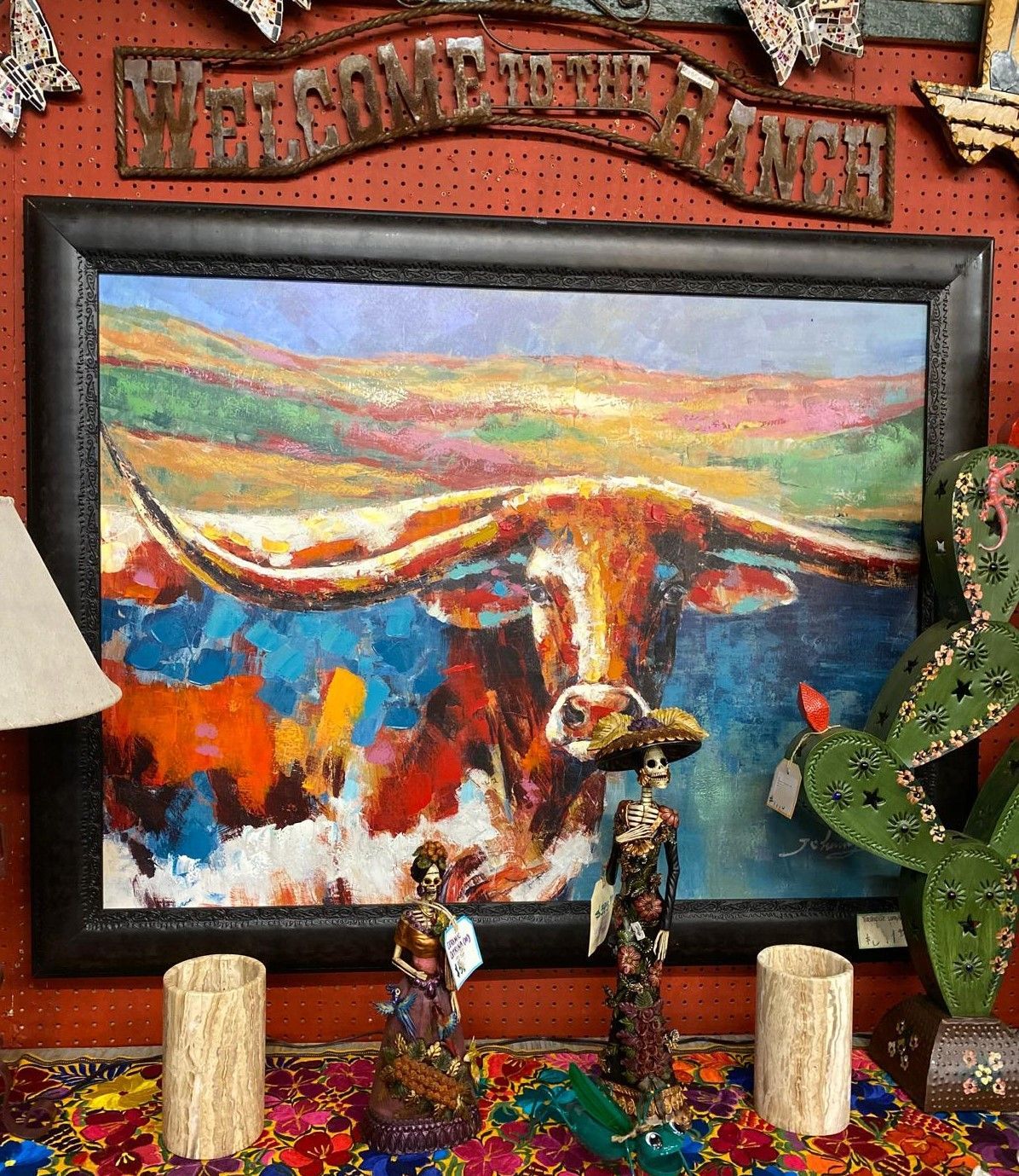 Painting of a longhorn bull with colorful abstract background, in a shop with southwestern decor.
