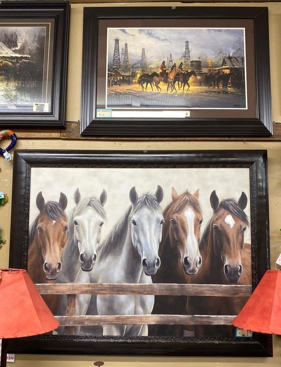Five horses of varying colors stand behind a wooden fence, framed by a large black rectangular frame.