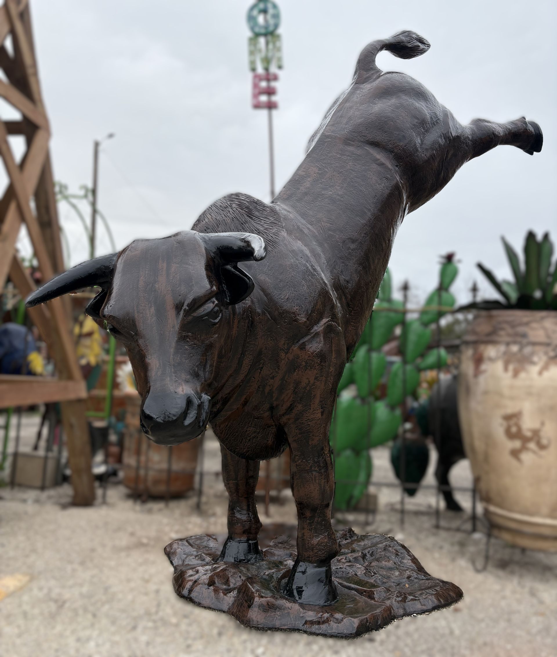 Bronze bull statue rearing up, possibly outdoors. Dark brown, textured finish.