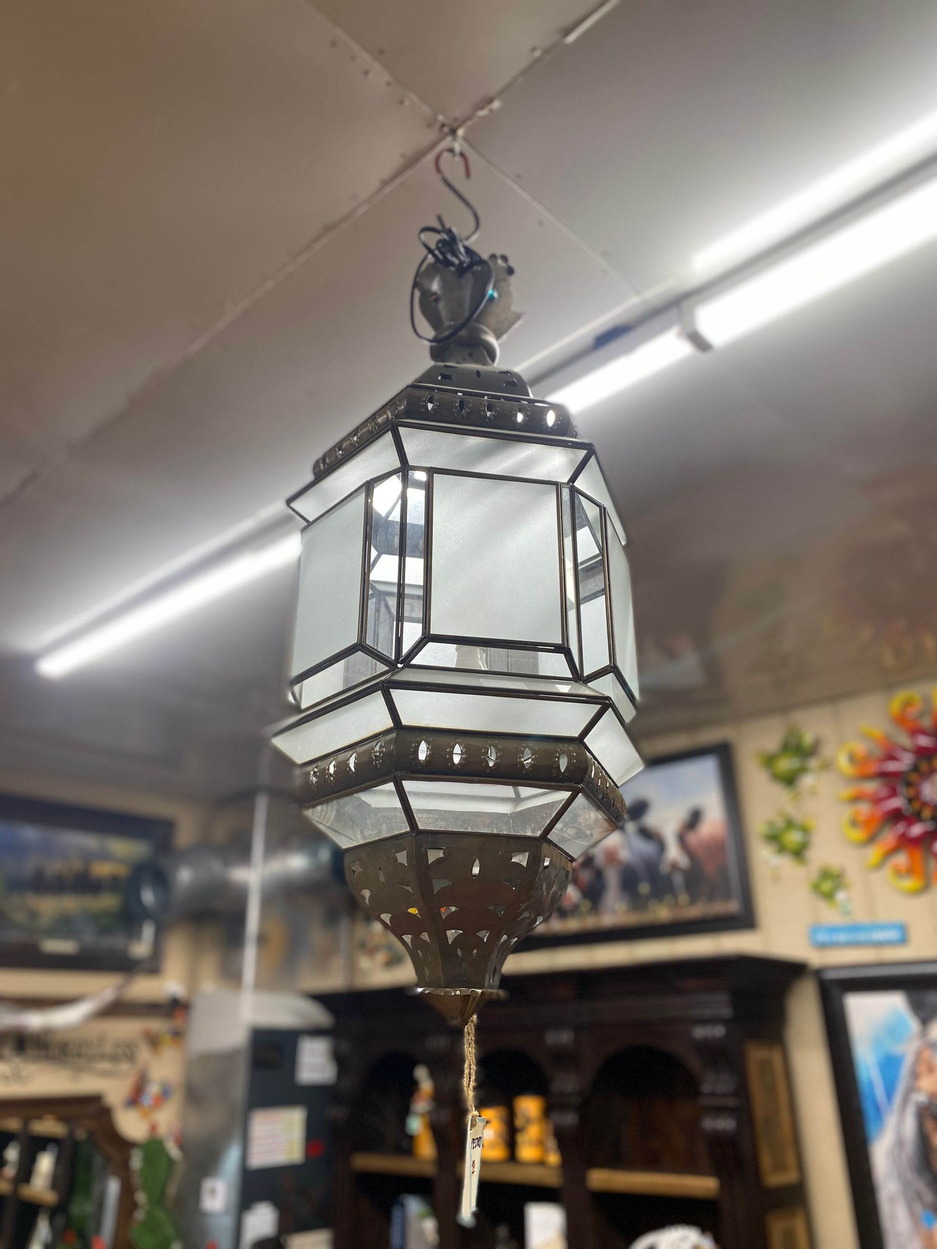 Hanging antique lantern with white frosted glass panels, metal frame, and a decorative base.