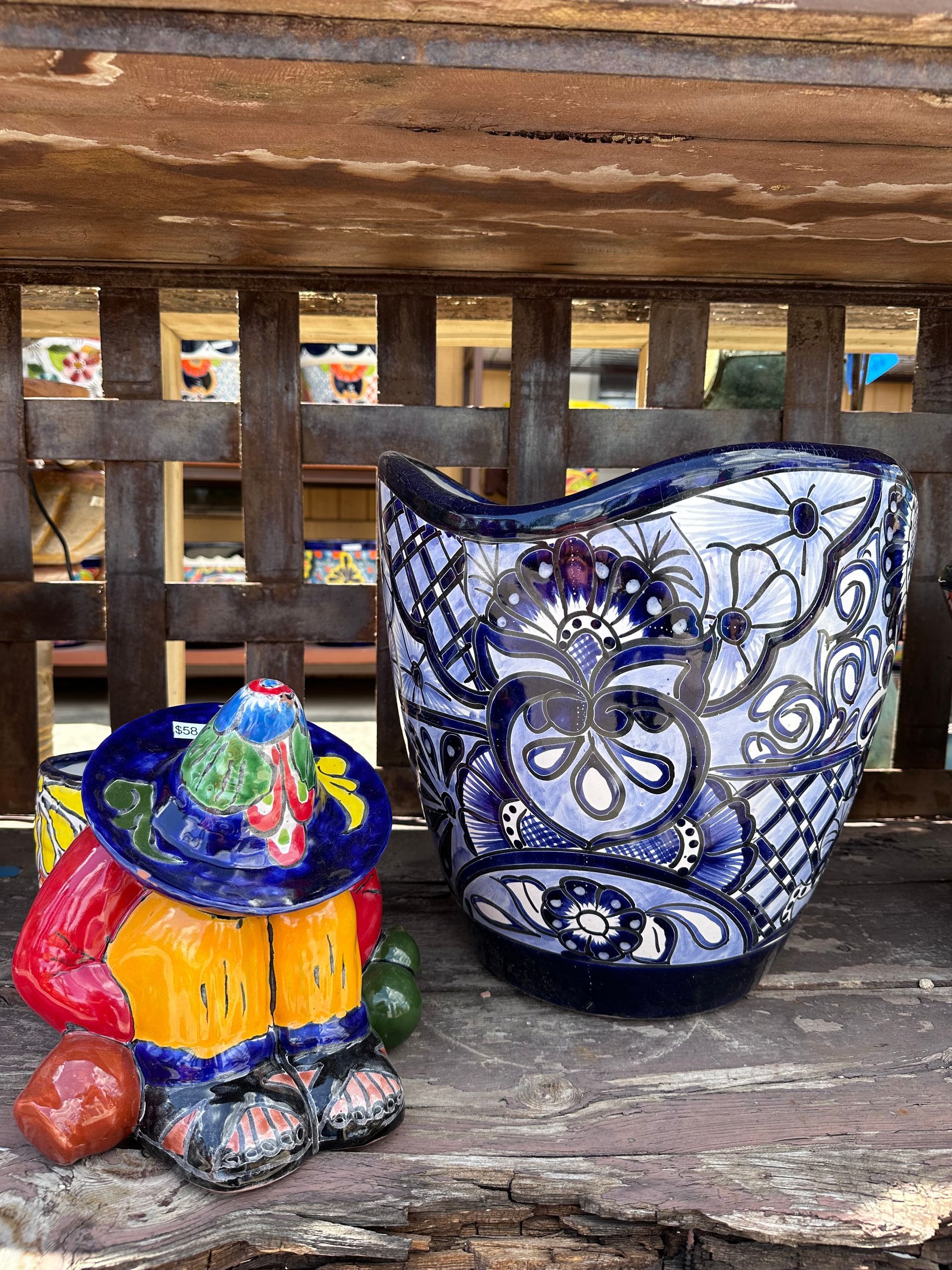 Ceramic vase and figurine. The vase is blue and white with floral patterns. The figurine depicts a person in colorful traditional clothing.