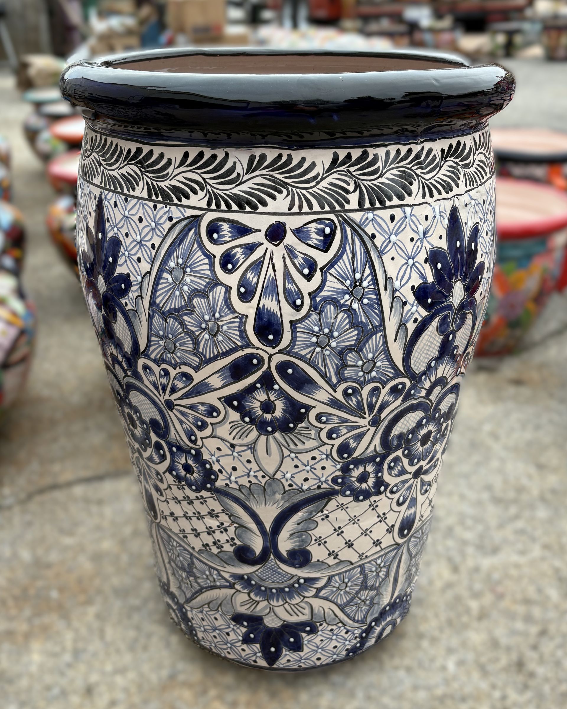 A blue and white ceramic planter with intricate floral patterns and a dark blue rim.