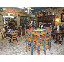 Interior of a rustic-themed restaurant with wooden tables and chairs, decorated with western and Southwestern motifs.