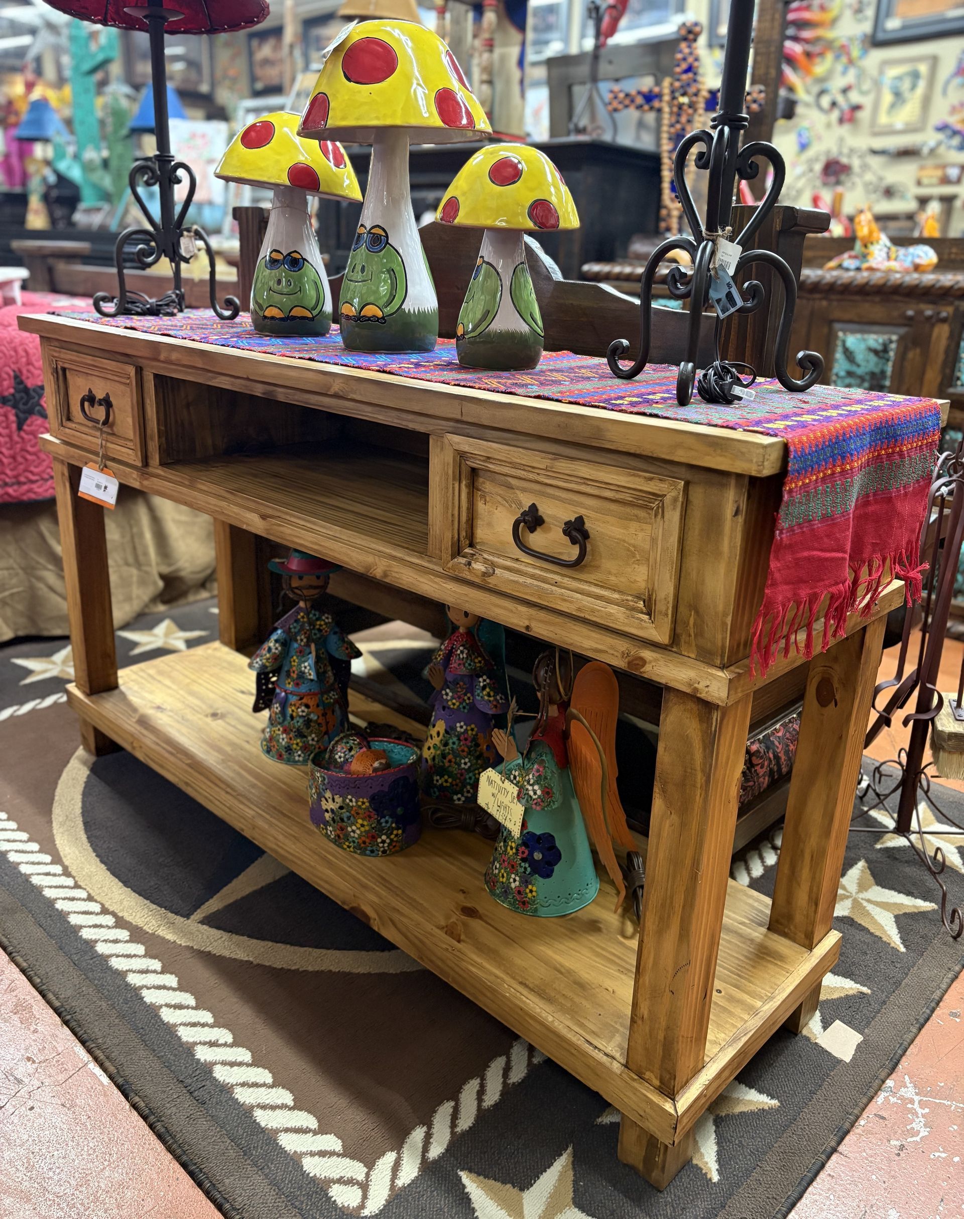 Wooden console table with mushroom lamps and decorative items in a shop setting.