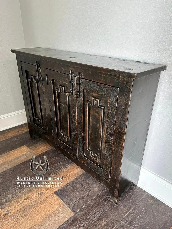 Dark brown, rustic wooden cabinet with three doors against a grey wall.