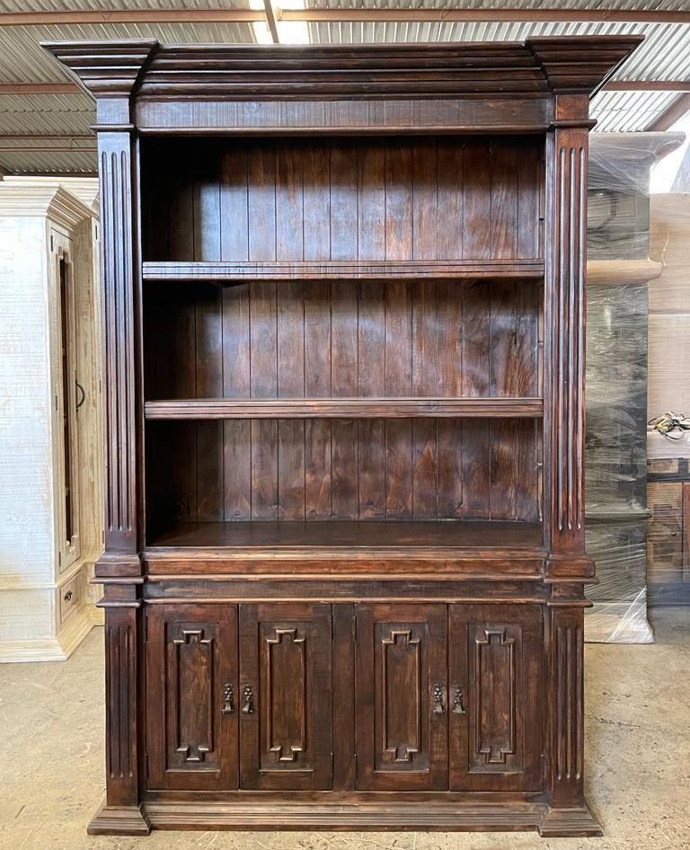 Dark wooden bookshelf with four cabinet doors below open shelves. Features columns on sides and detailed molding.