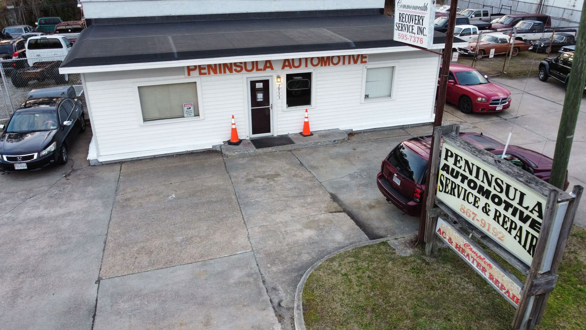 Peninsula Automotive storefront and roadside sign with parked cars in the lot