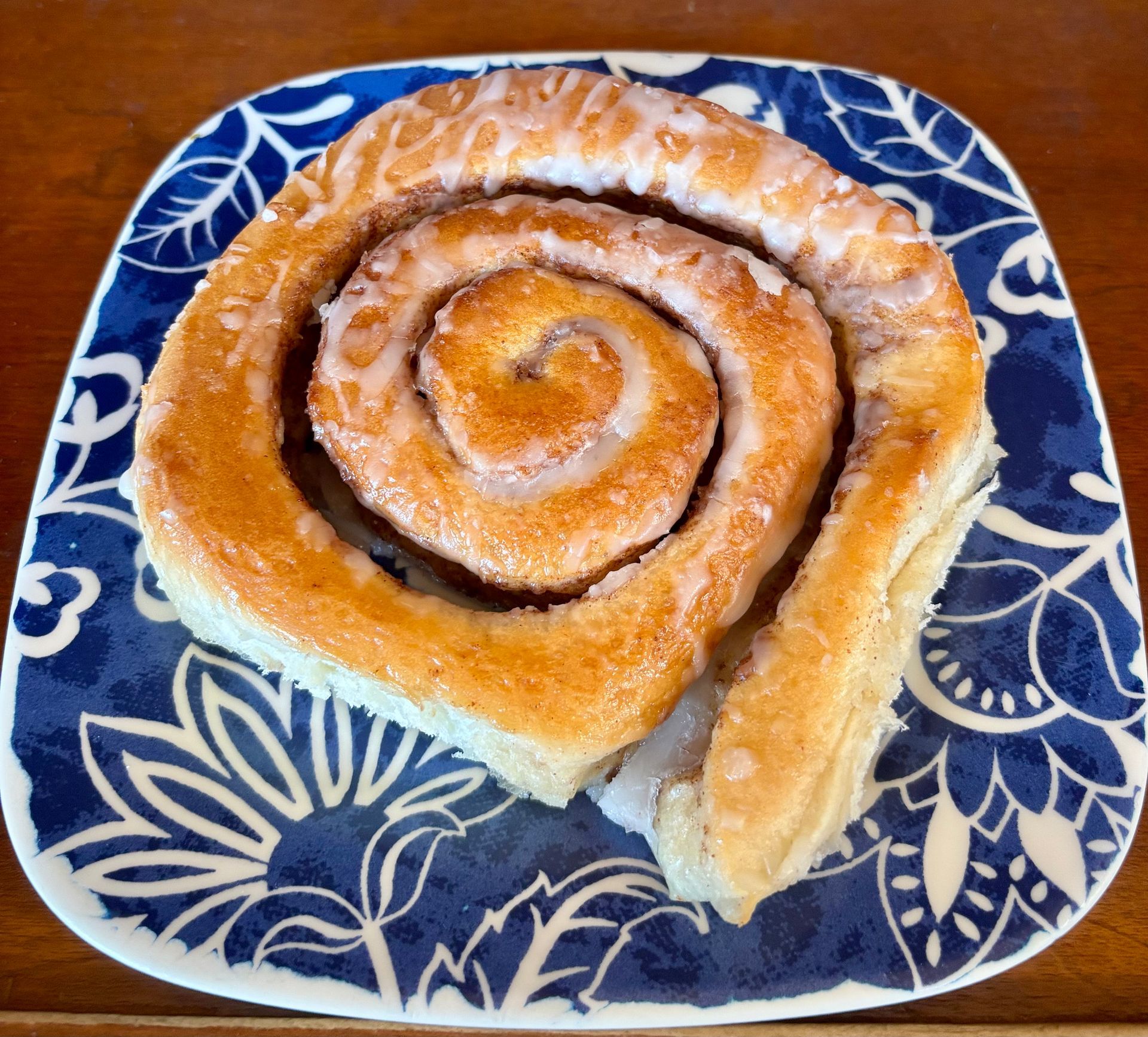 Swirled cinnamon pastry on a blue floral plate