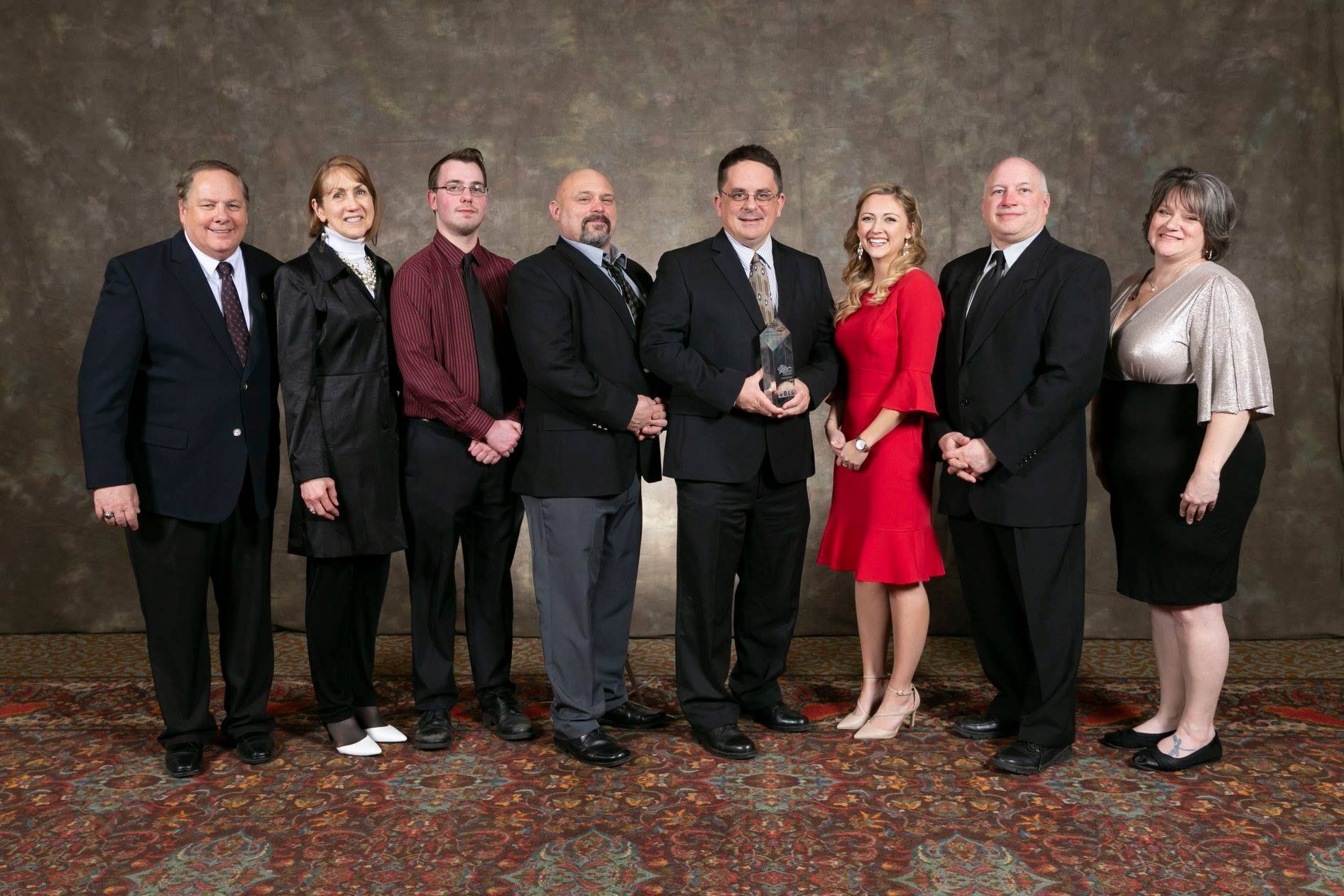 A group of people posing for a picture with an award