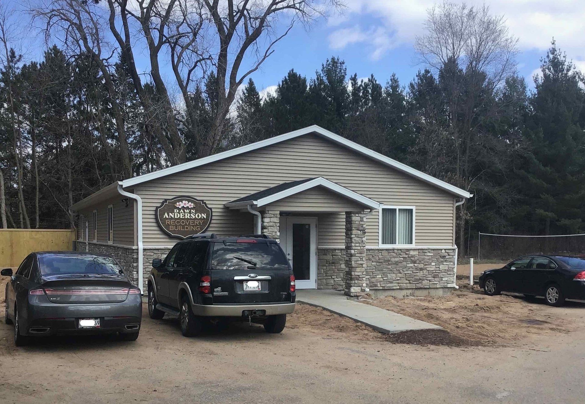 A large house with a roof that is surrounded by trees.