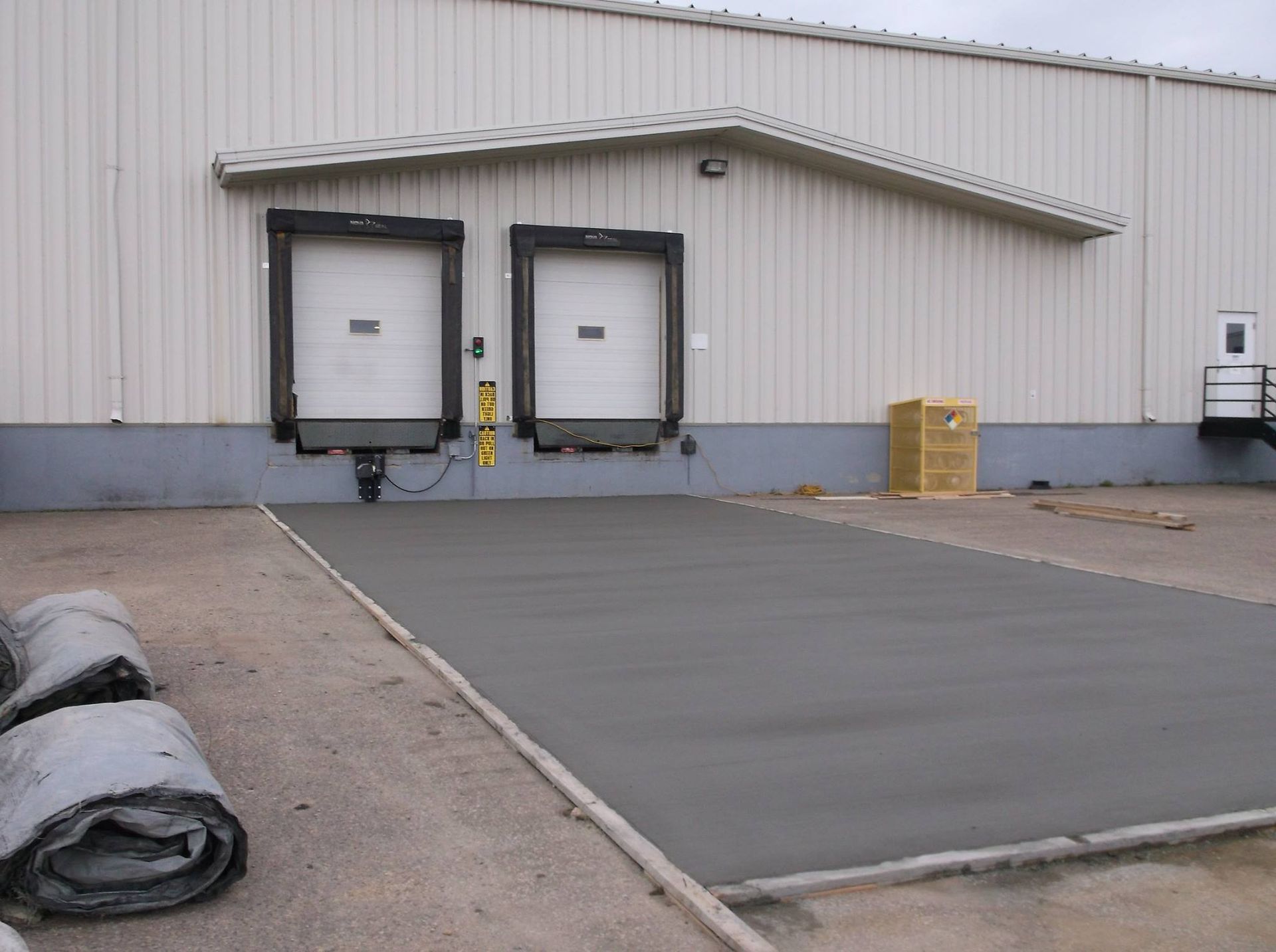 A warehouse with a concrete driveway in front of it