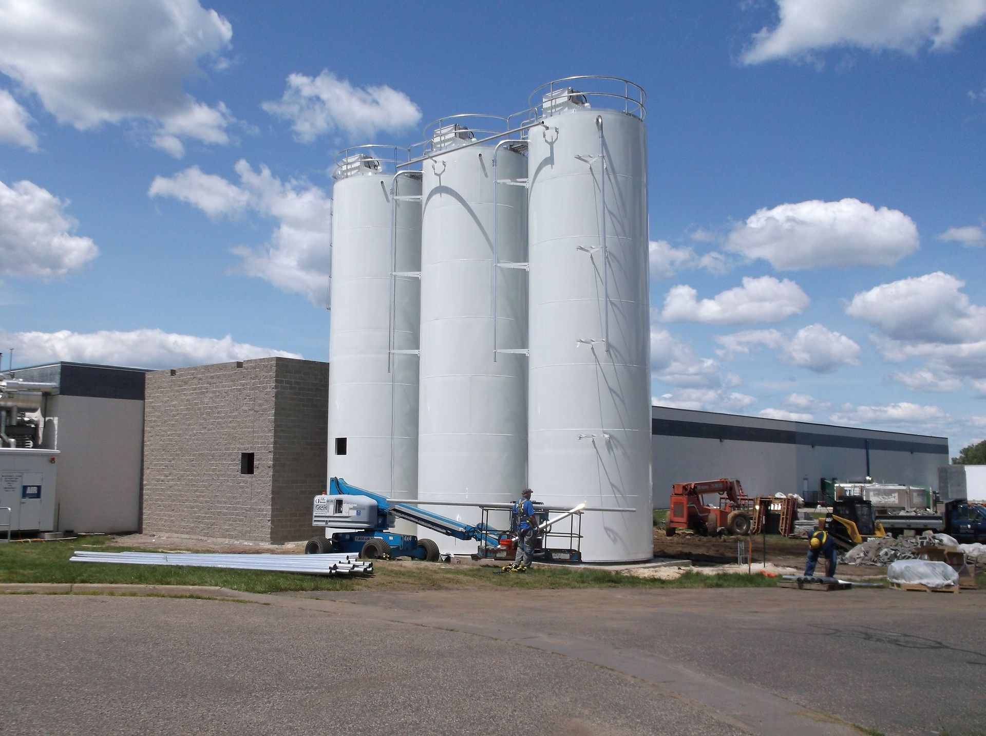 A large white building with three silos in front of it