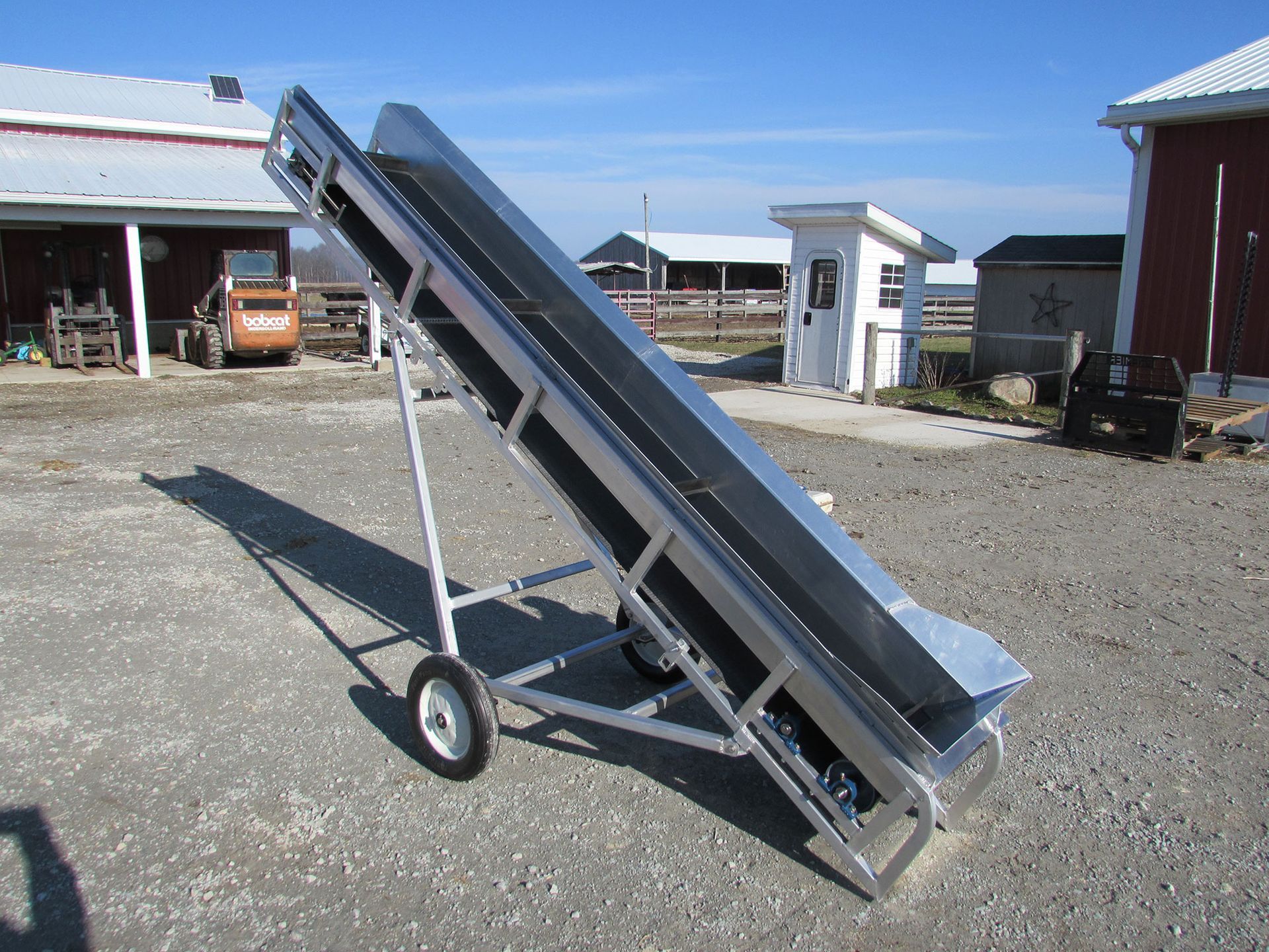 A conveyor belt is sitting on the ground in front of a building
