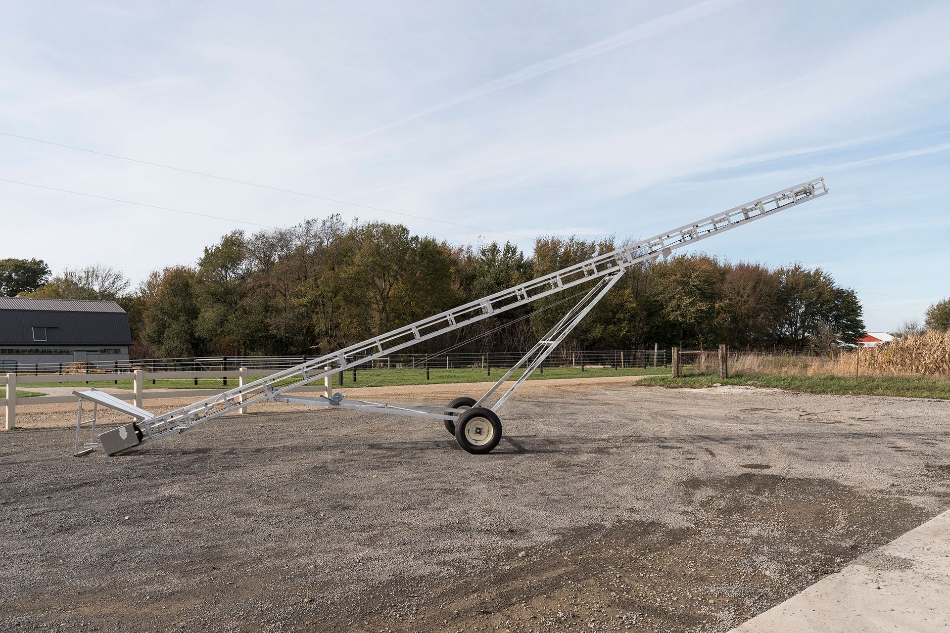 A conveyor belt is sitting on top of a gravel road.