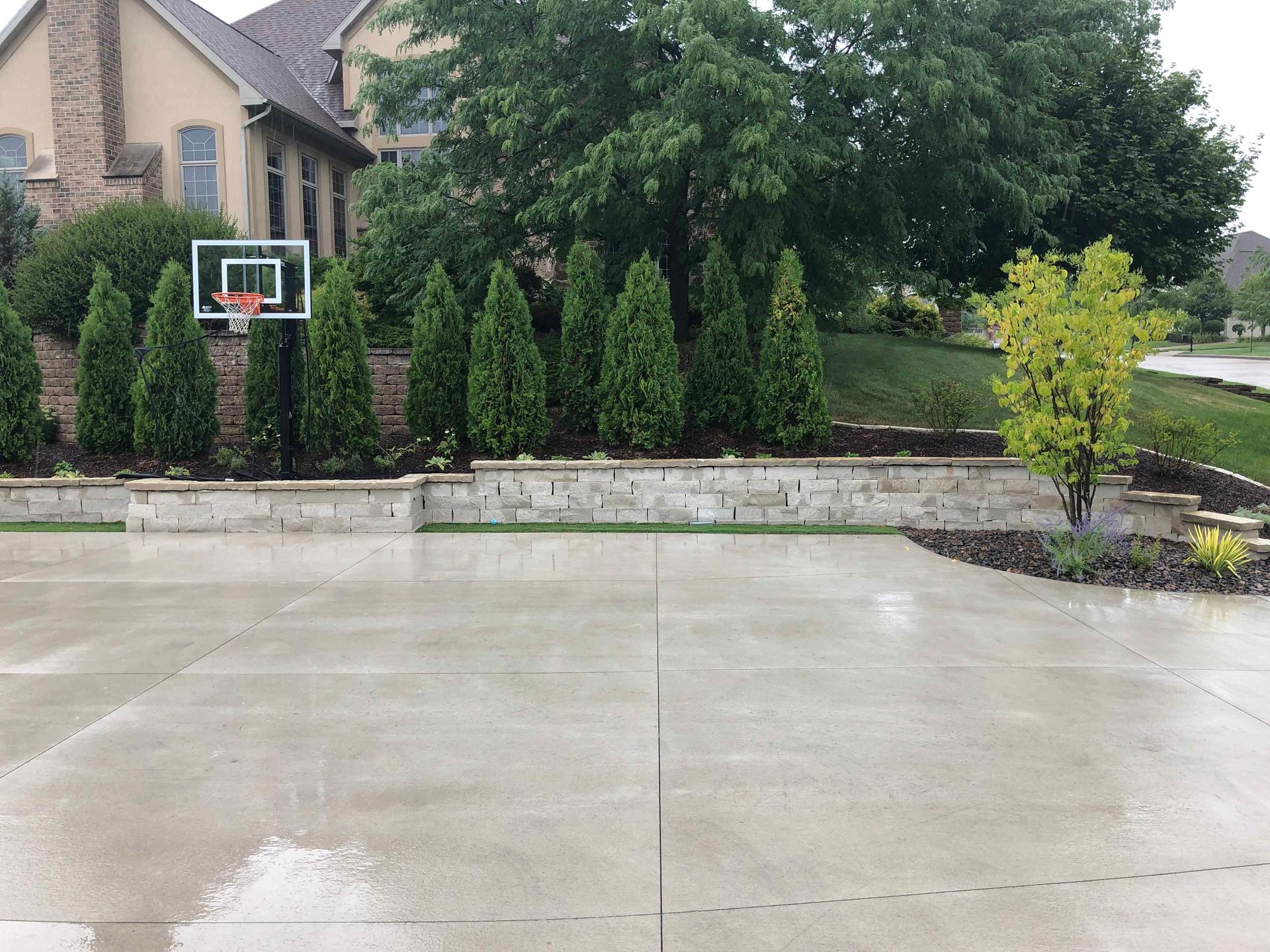 A basketball hoop in a driveway in front of a house