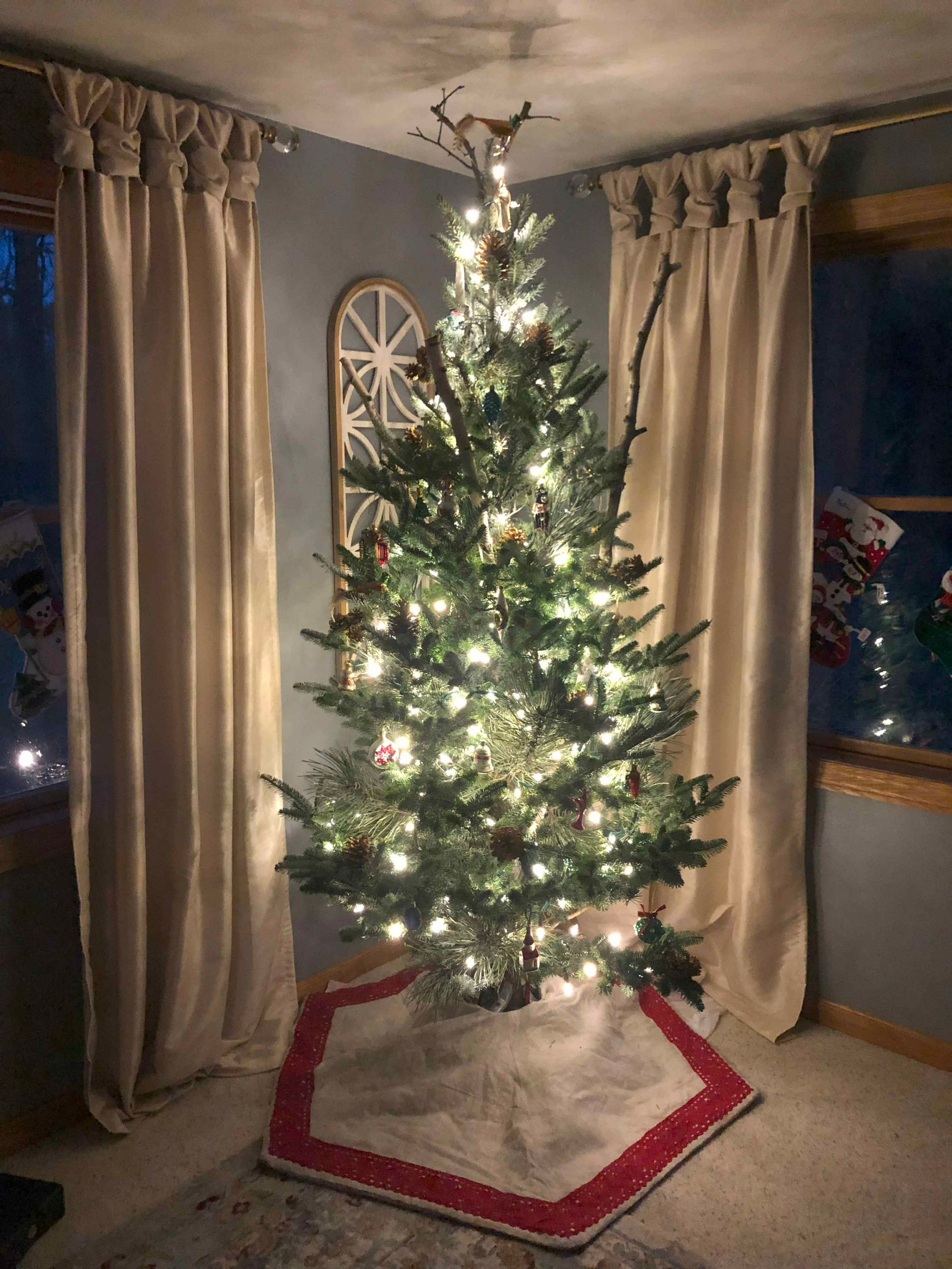 A christmas tree is sitting in the corner of a living room.