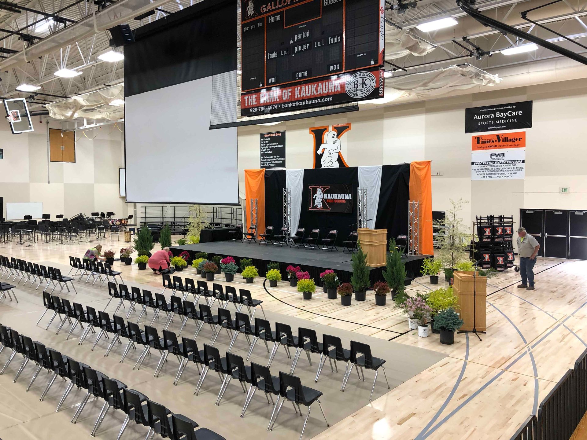 A large auditorium with rows of chairs and a stage.