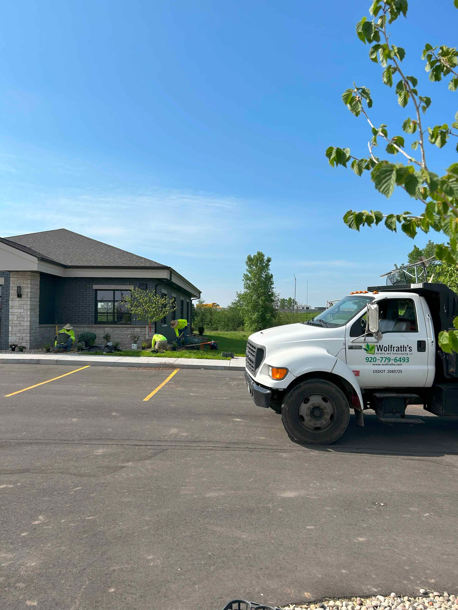 A white truck is parked in a parking lot in front of a house.