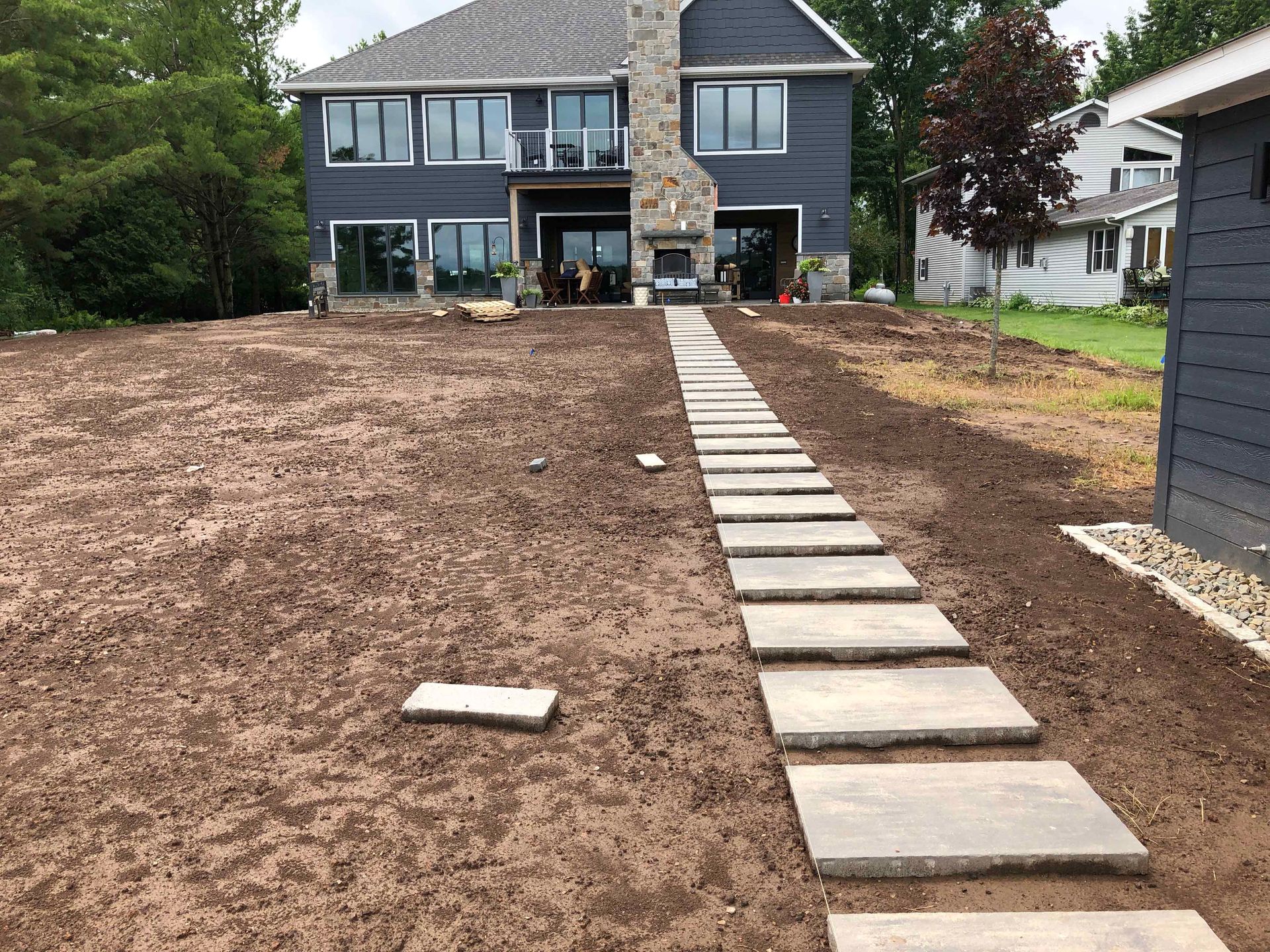A large house with a stone walkway leading to it.