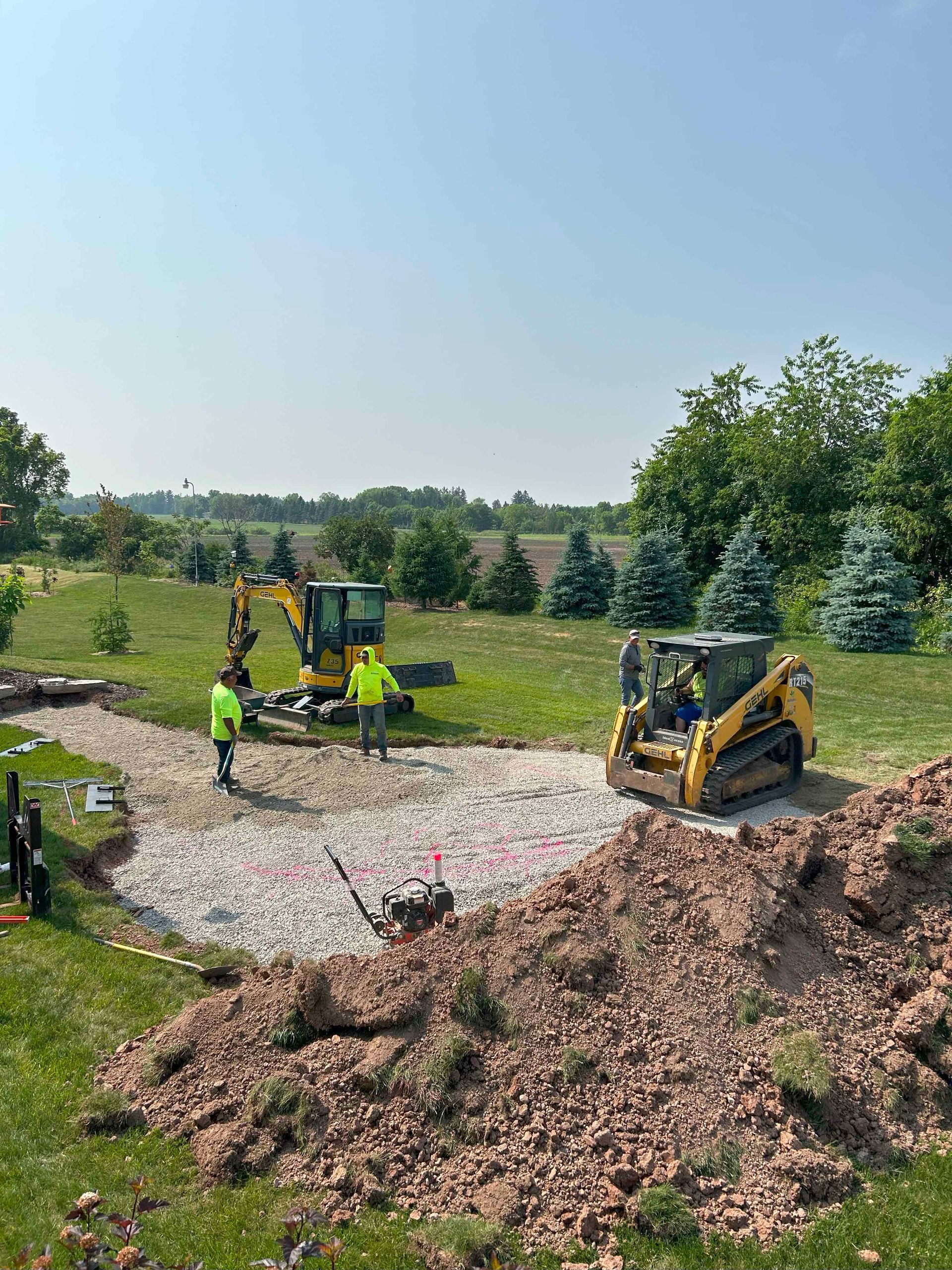 A bulldozer is being used to build a patio in a yard.