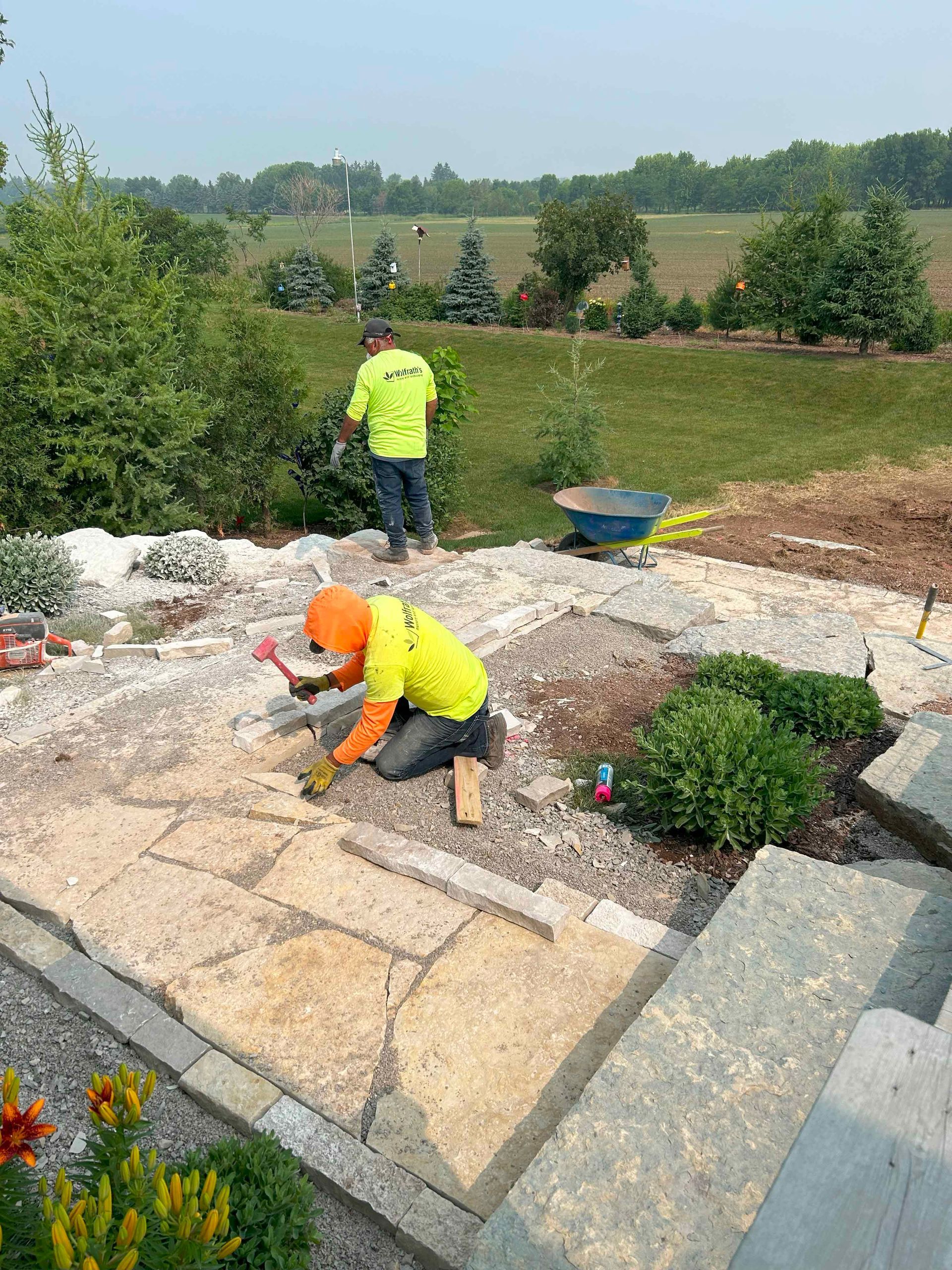 A group of men are working on a stone patio.