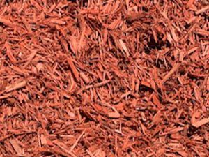 A pile of red mulch is sitting on the ground.