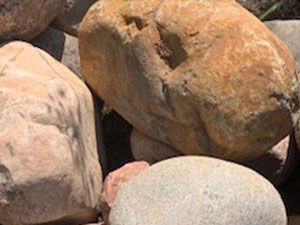 A pile of rocks sitting on top of each other on the ground.